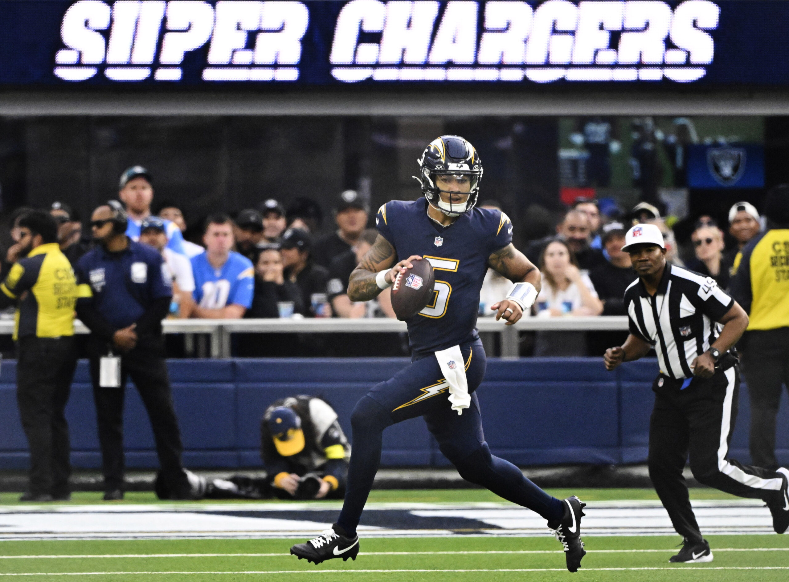 Quarterback Trey Lance #5 of the Los Angeles Chargers scrambles...