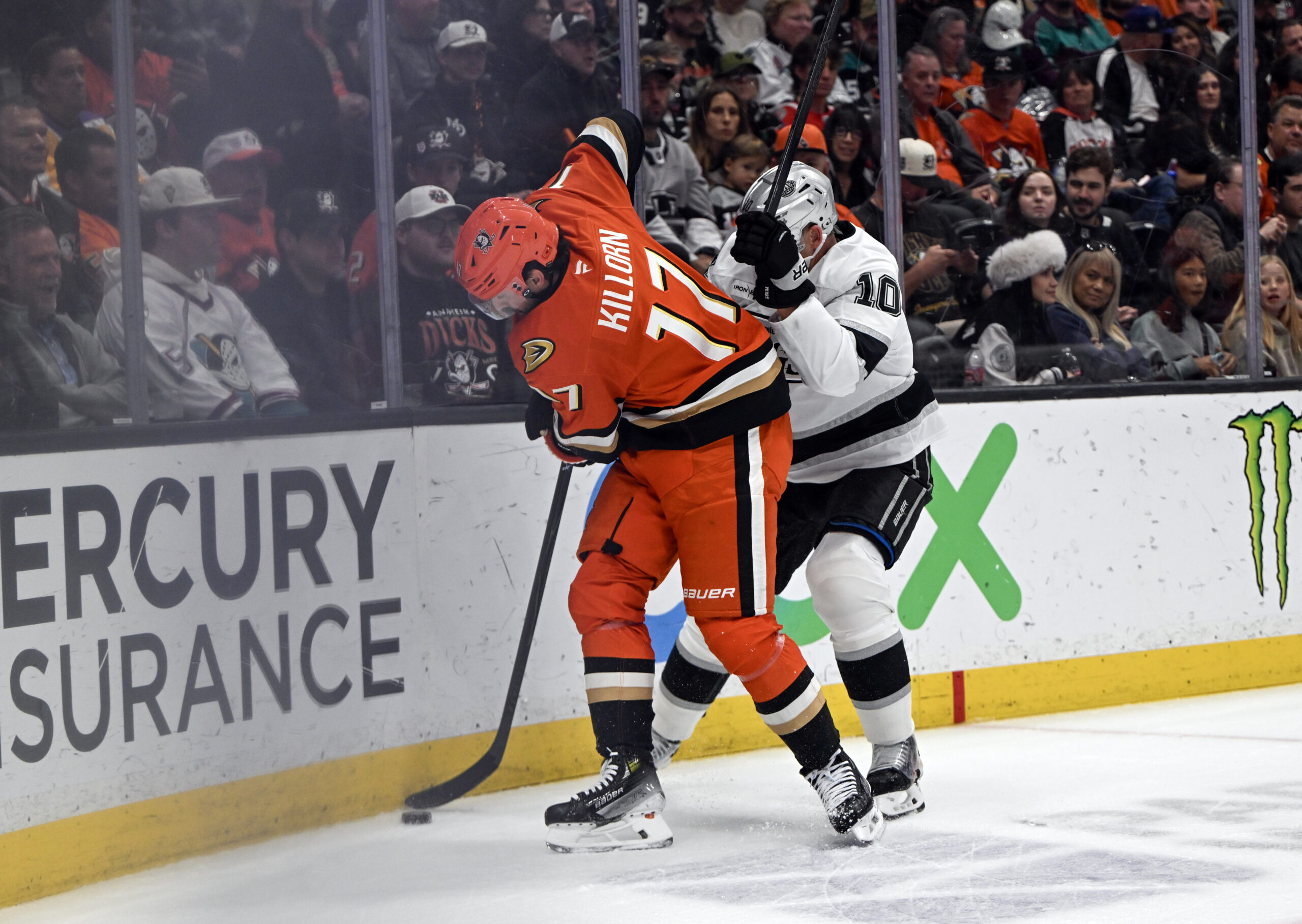 The Kings’ Corey Perry, right, tries to get the puck...