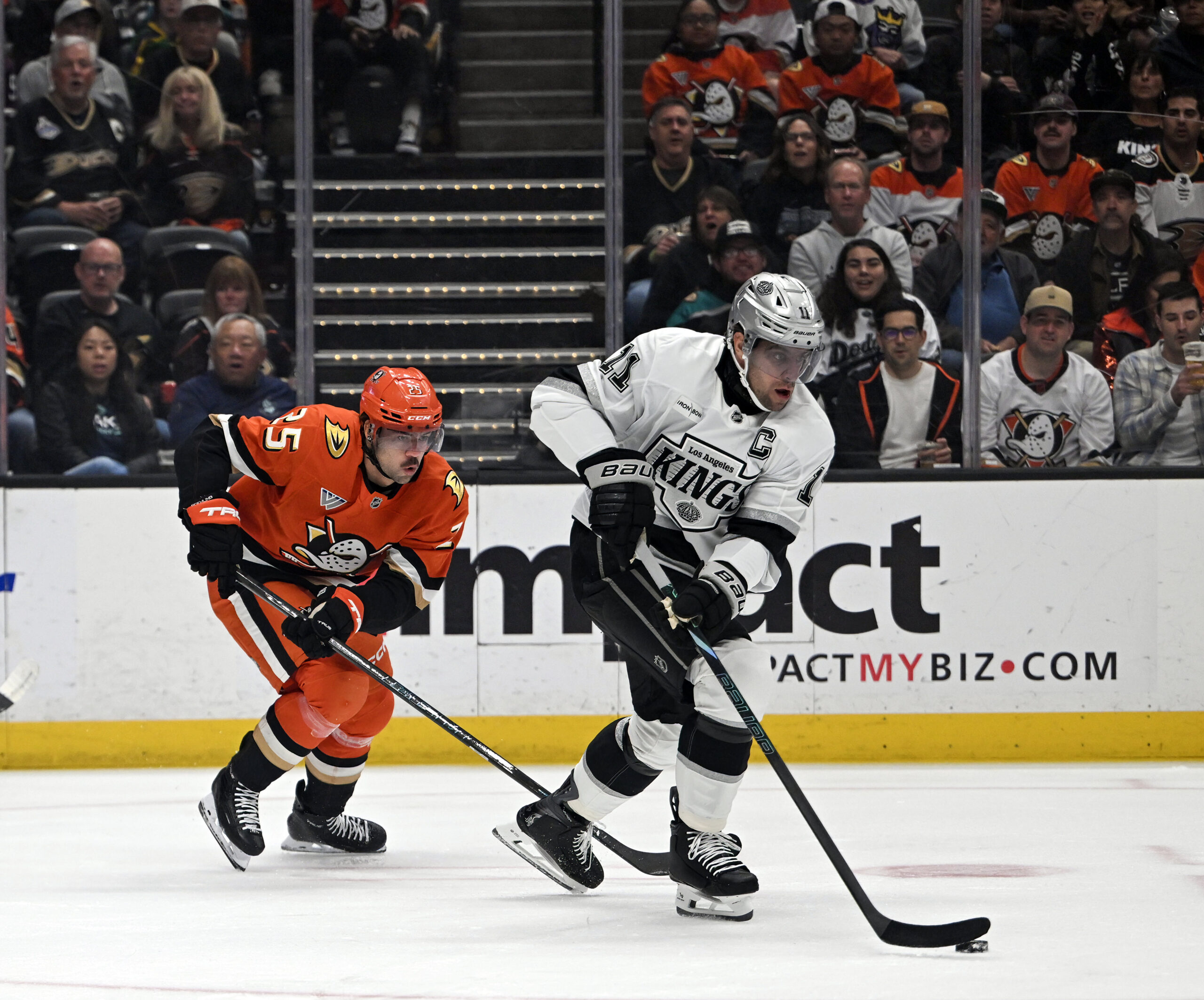 The Kings’ Anze Kopitar, right, handles the puck as the...