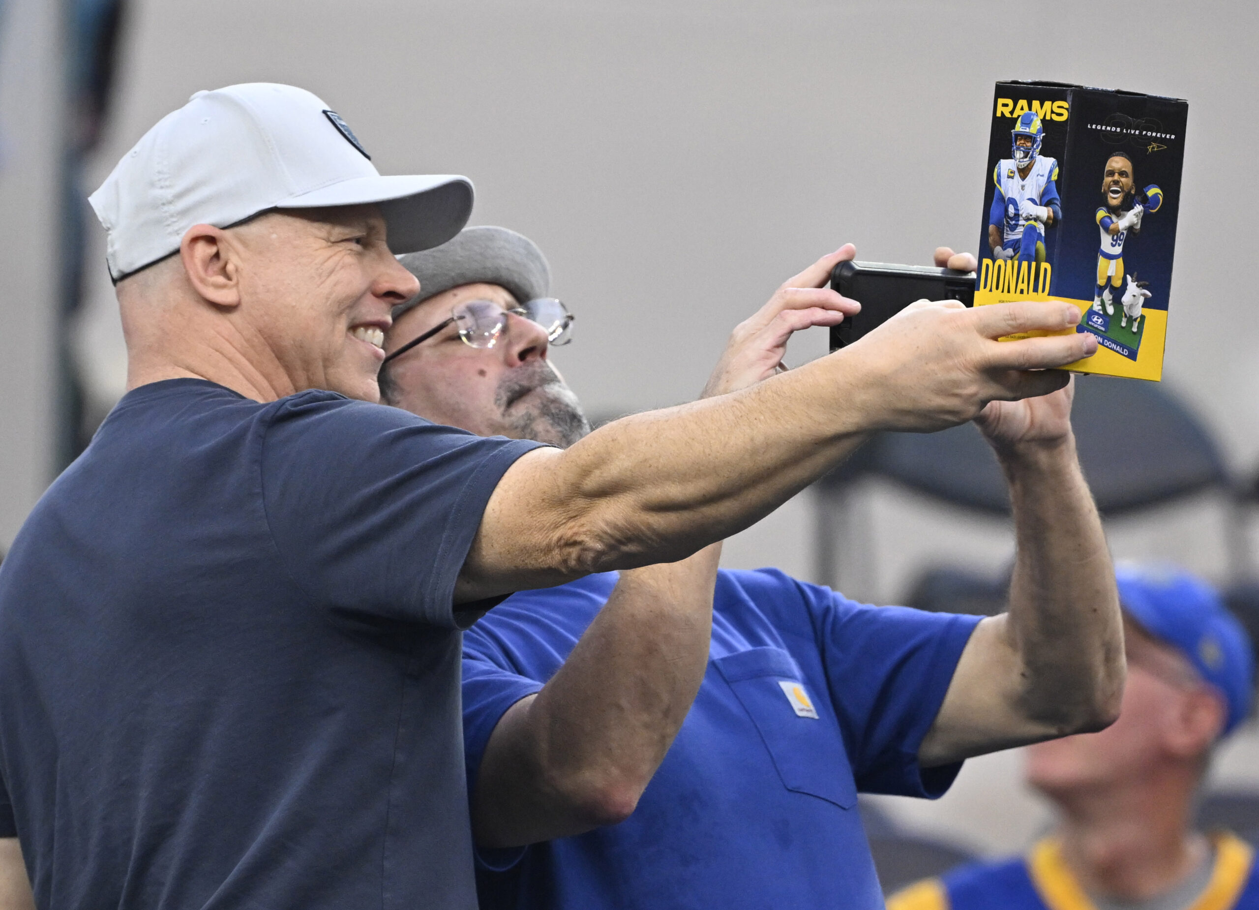 Fans take pictures of the former Rams Aaron Donald bobblehead...