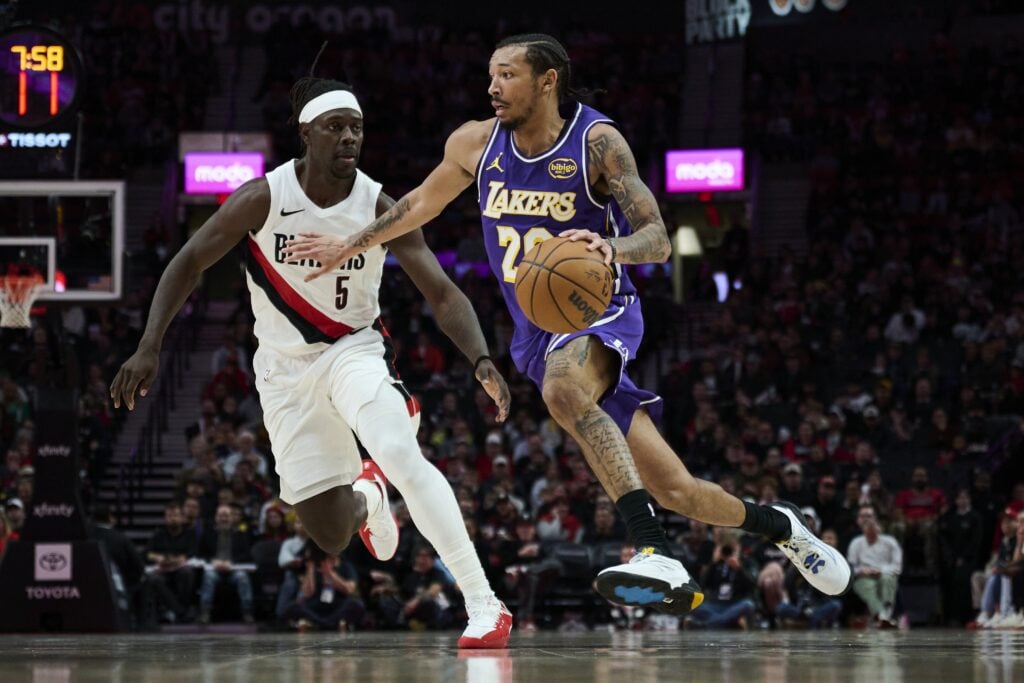 Nov 3, 2025; Portland, Oregon, USA; Los Angeles Lakers guard Nick Smith Jr. (20) drives to the basket during the second half against Portland Trail Blazers guard Jrue Holiday (5) at Moda Center. Mandatory Credit: Troy Wayrynen-Imagn Images