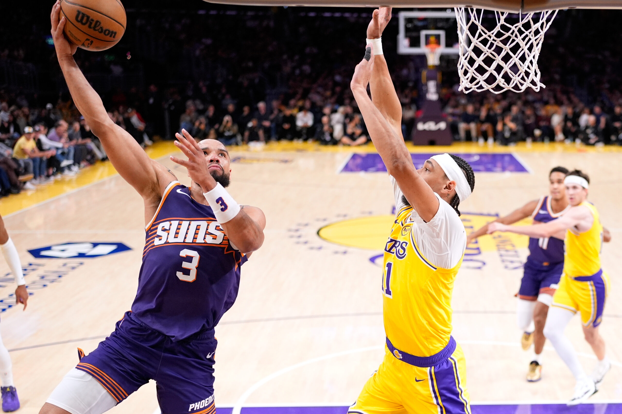 Phoenix Suns forward Dillon Brooks, left, shoots as Lakers center...