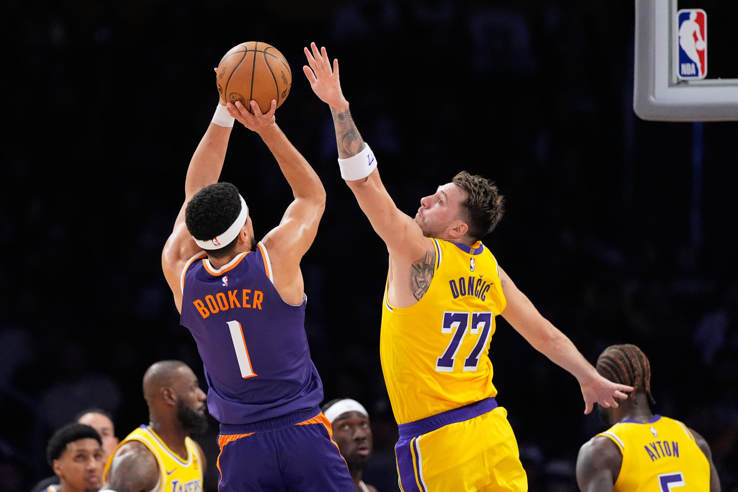 Phoenix Suns guard Devin Booker, left, shoots as Lakers guard...