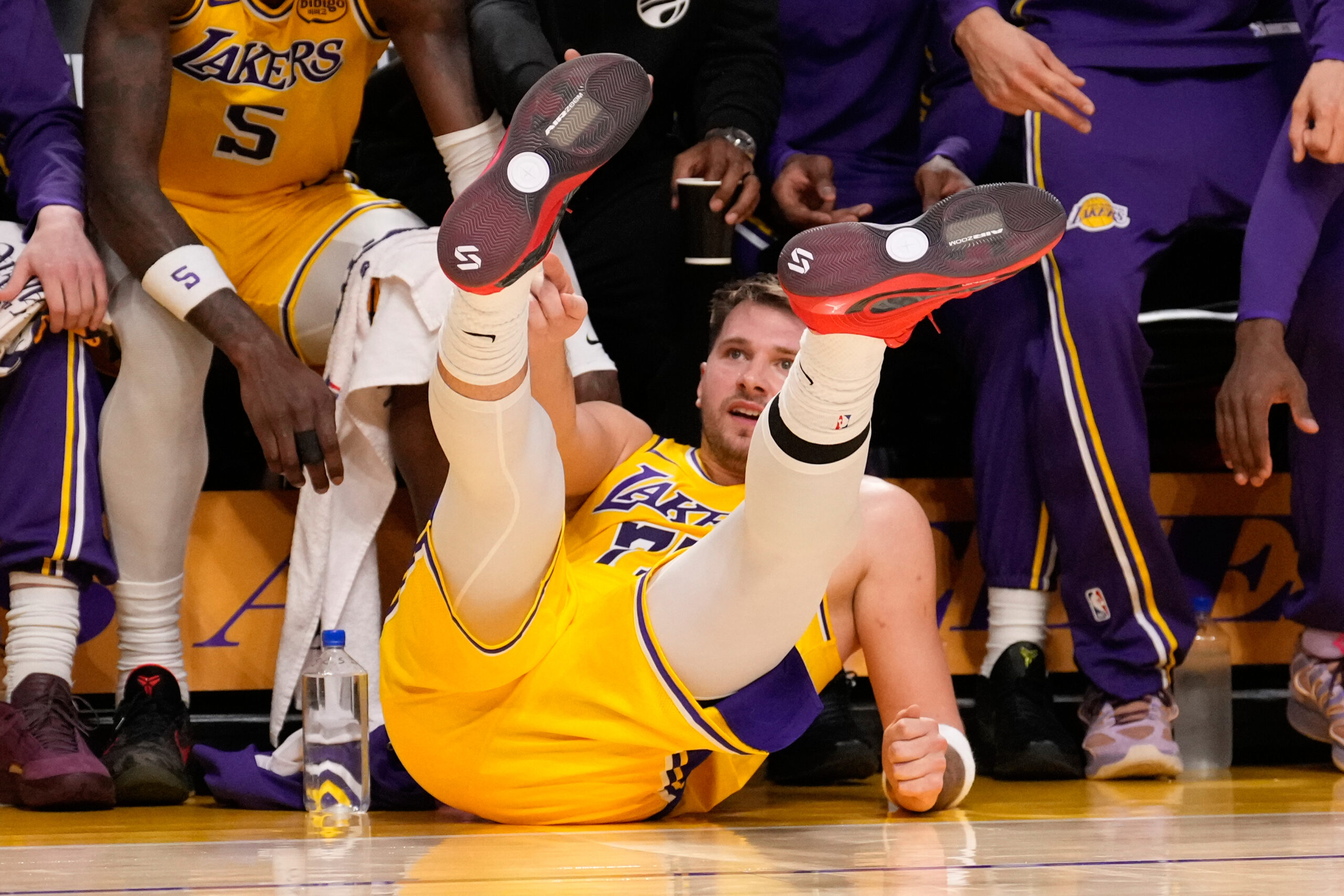 Lakers star Luka Doncic falls to the floor after making...