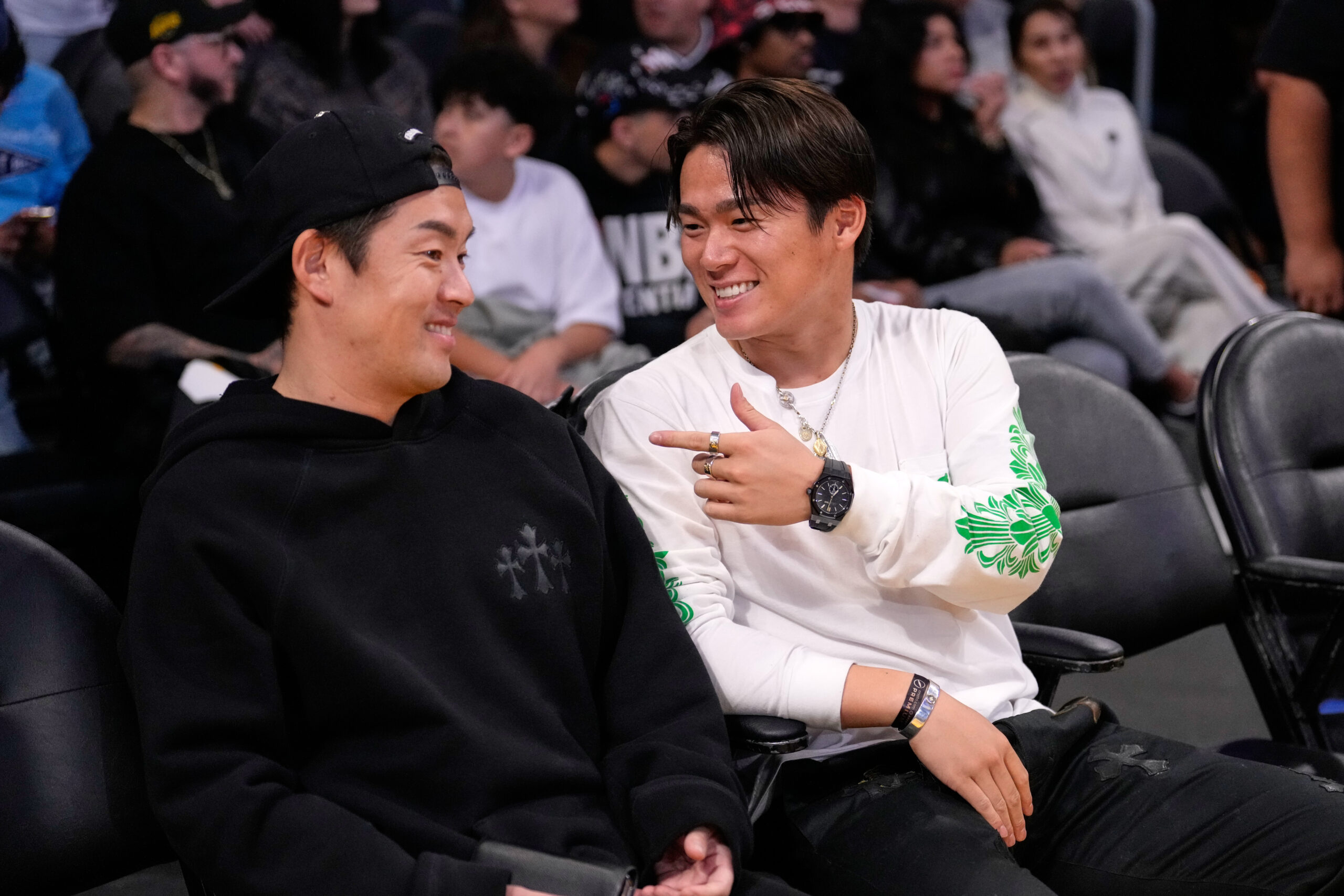 Dodgers pitcher Yoshinobu Yamamoto, right, attends an NBA game between...
