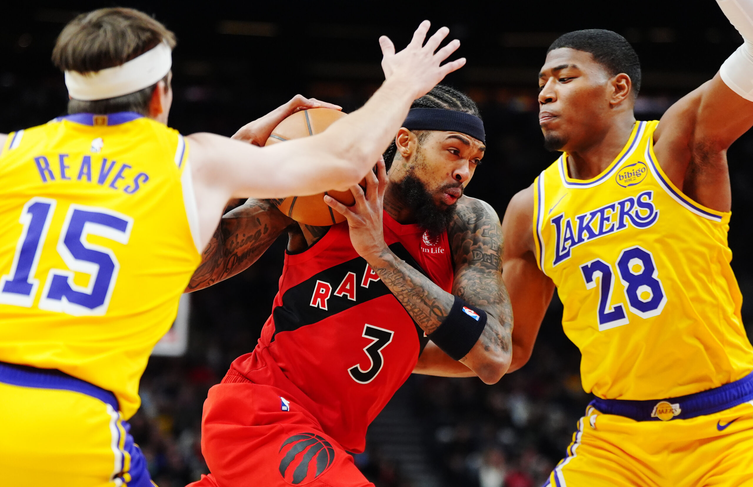 The Toronto Raptors’ Brandon Ingram drives between the Lakers’ Austin...