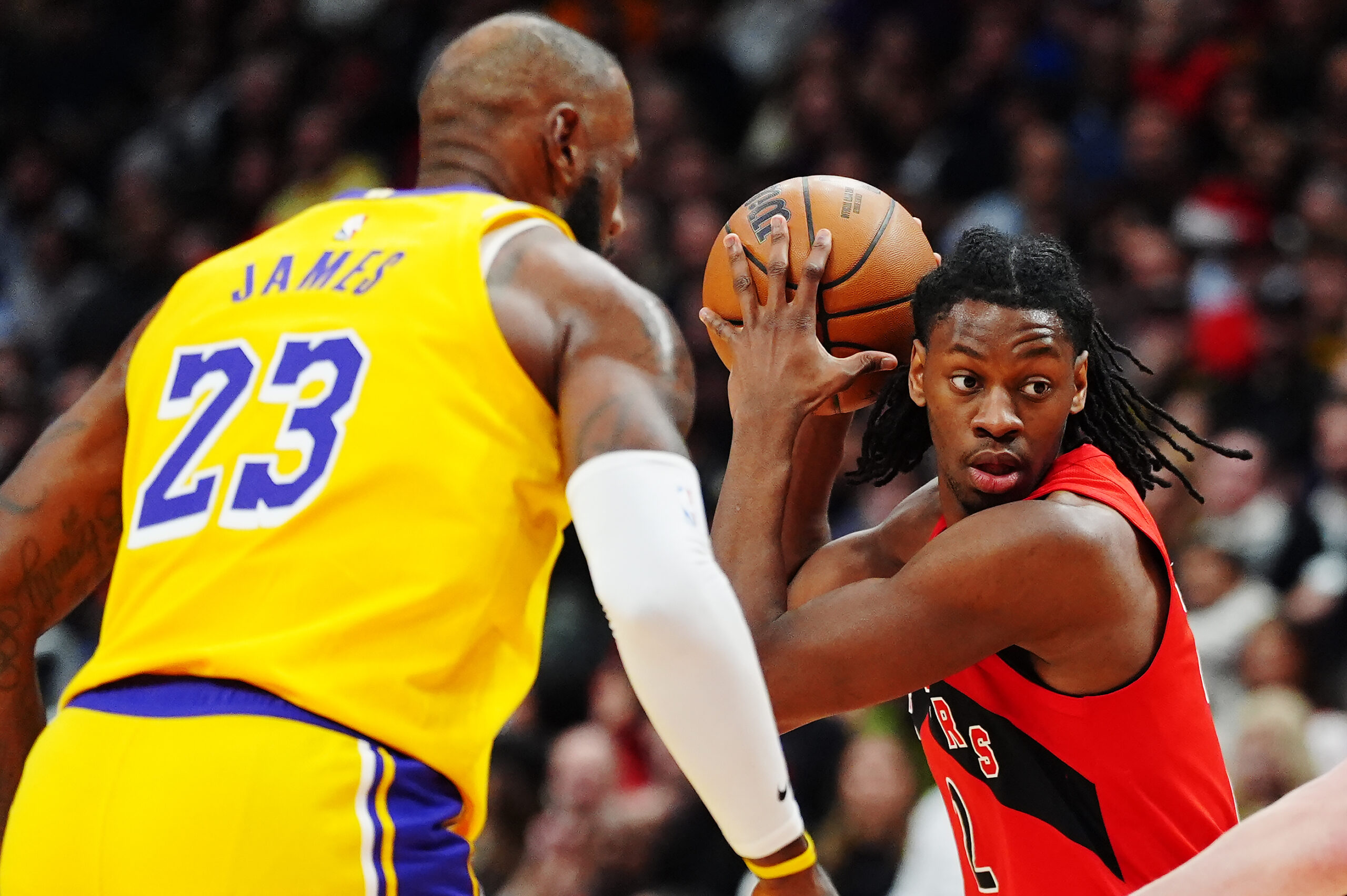The Toronto Raptors’ Jonathan Mogbo protects the ball from Lakers...