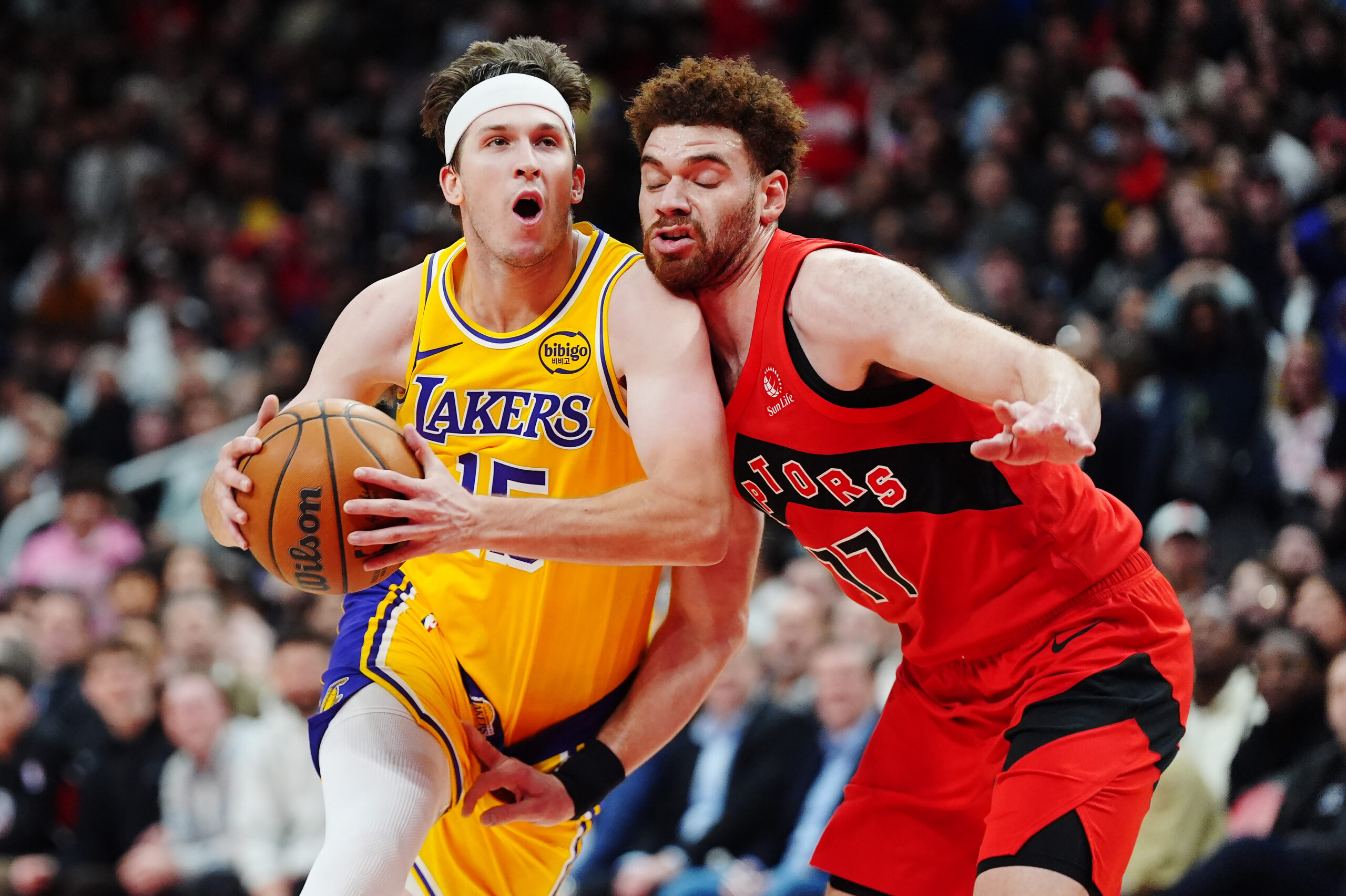 Lakers guard Austin Reaves, left, drives past the Toronto Raptors’...