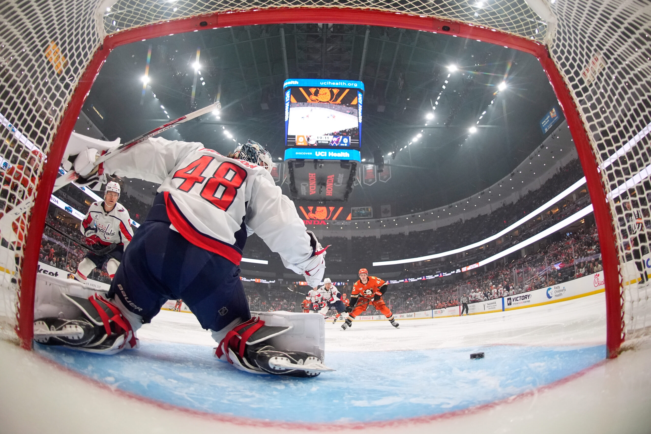 Washington Capitals goaltender Logan Thompson, left, deflects a shot as...