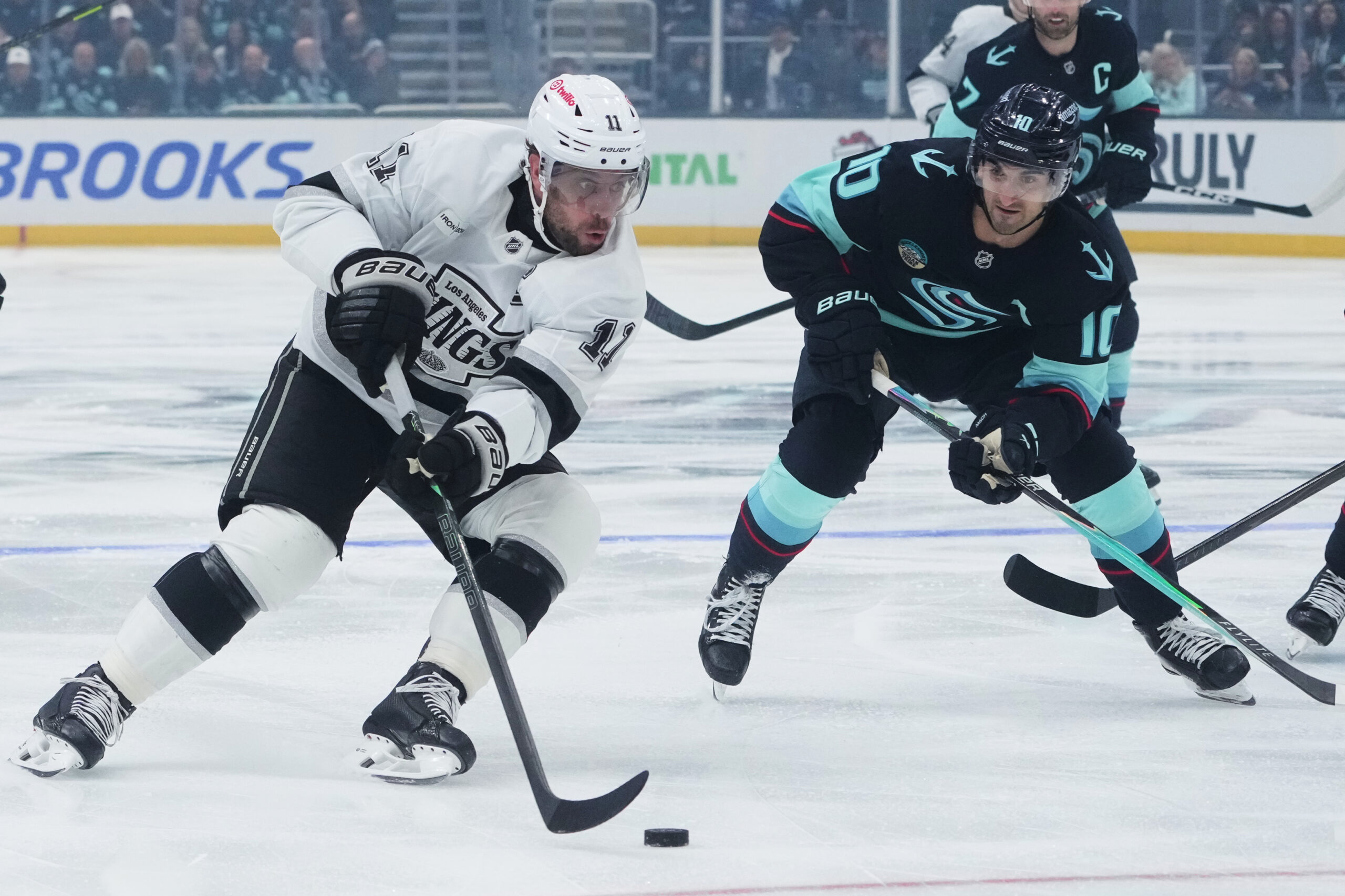 Kings center Anze Kopitar, left, pushes past Seattle Kraken center...