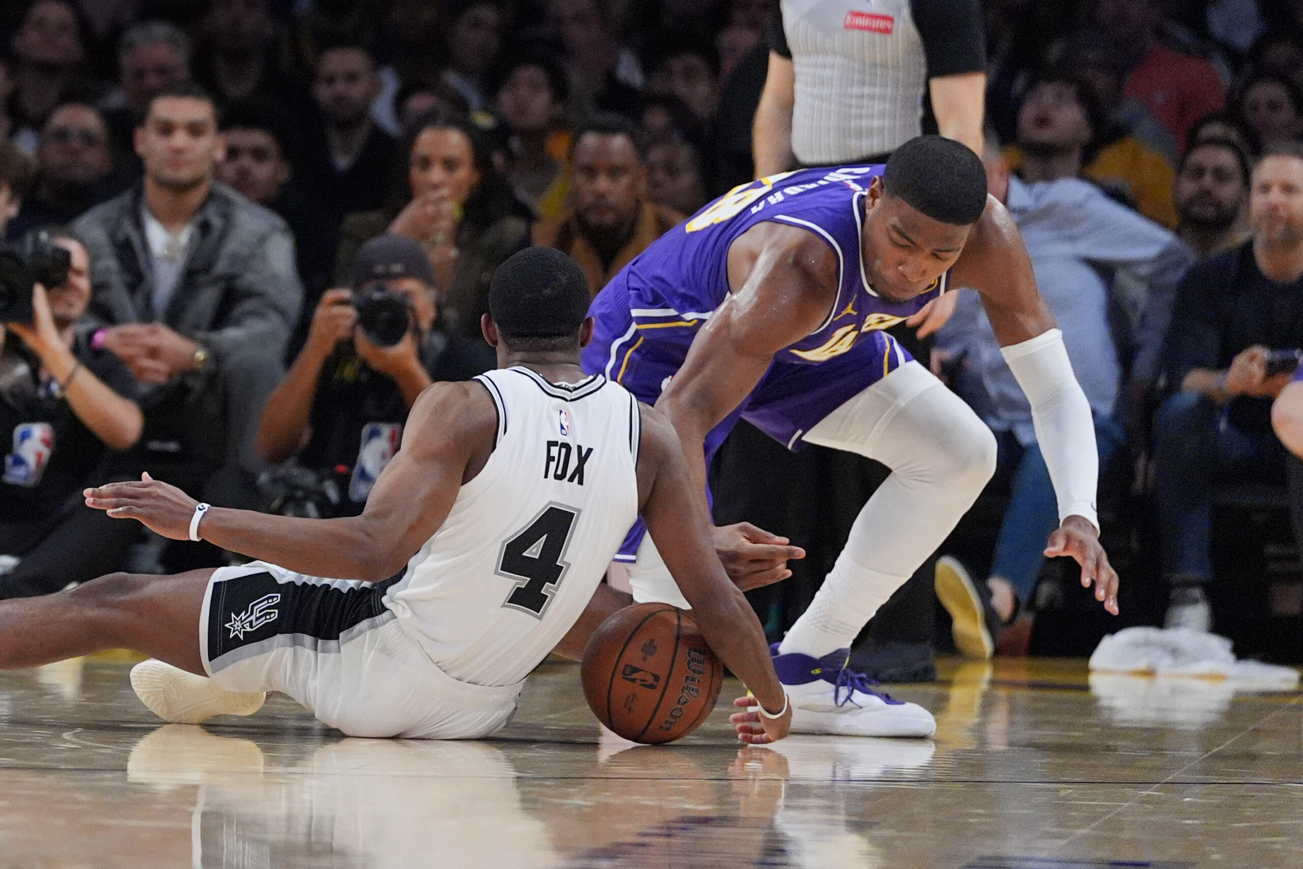 Lakers forward Rui Hachimura, right, battles for a loose ball...