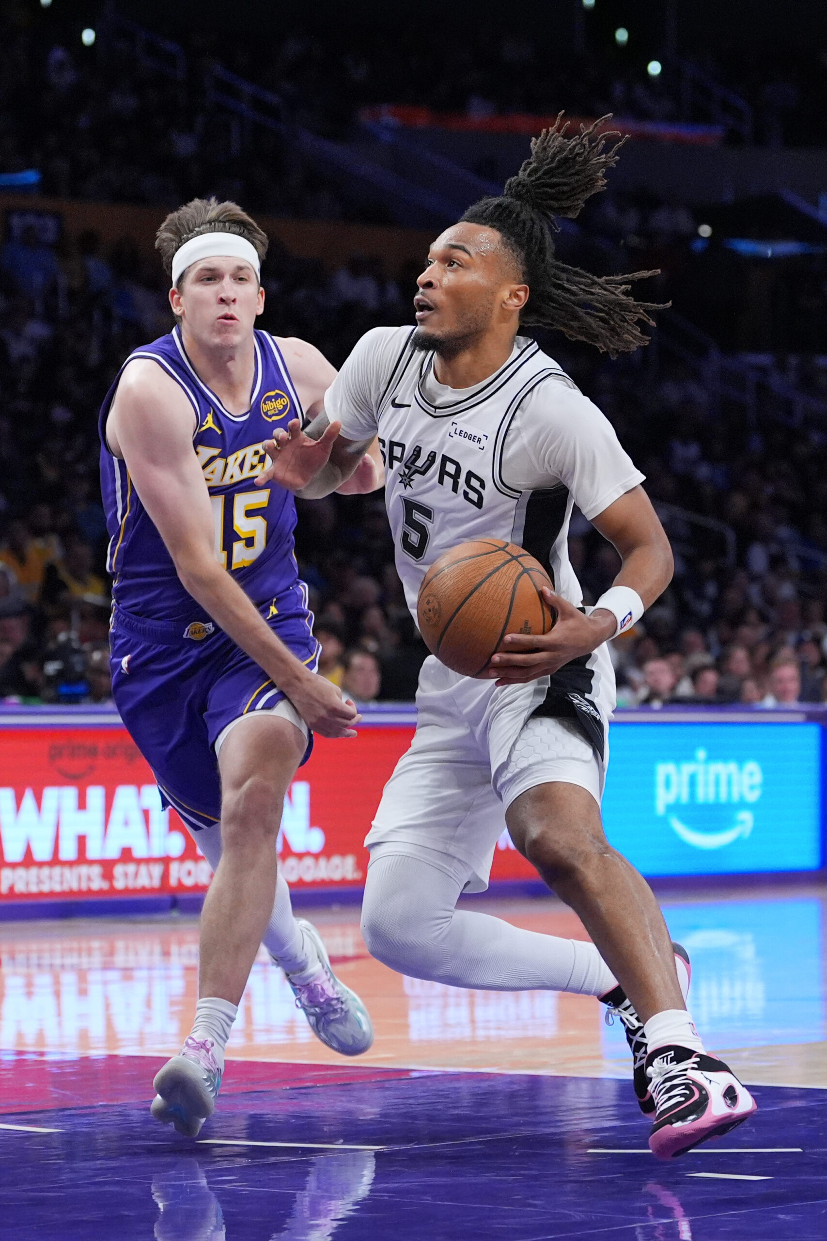 San Antonio Spurs guard Stephon Castle drives past Lakers guard...