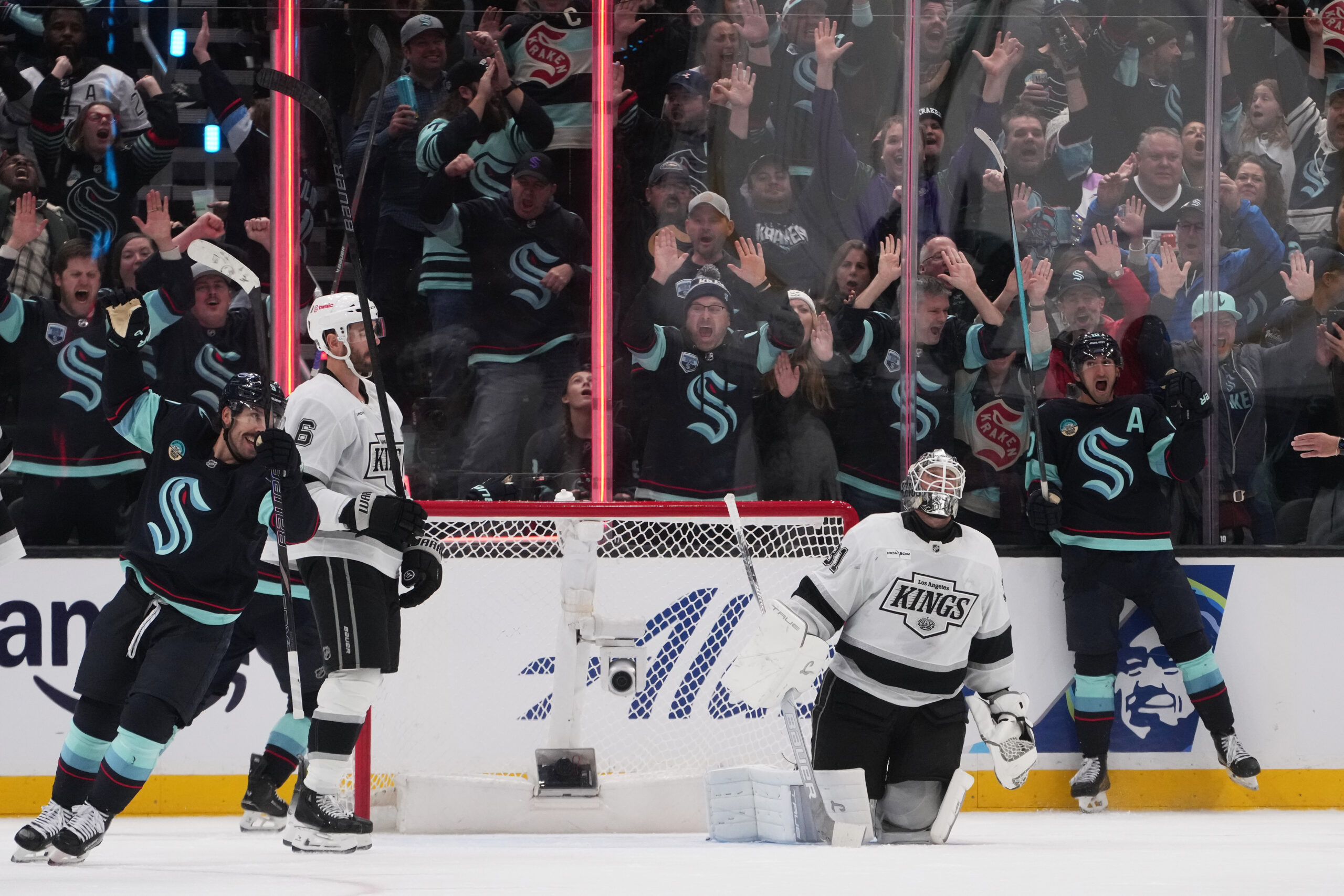 Seattle Kraken center Matty Beniers, far right, reacts after scoring...