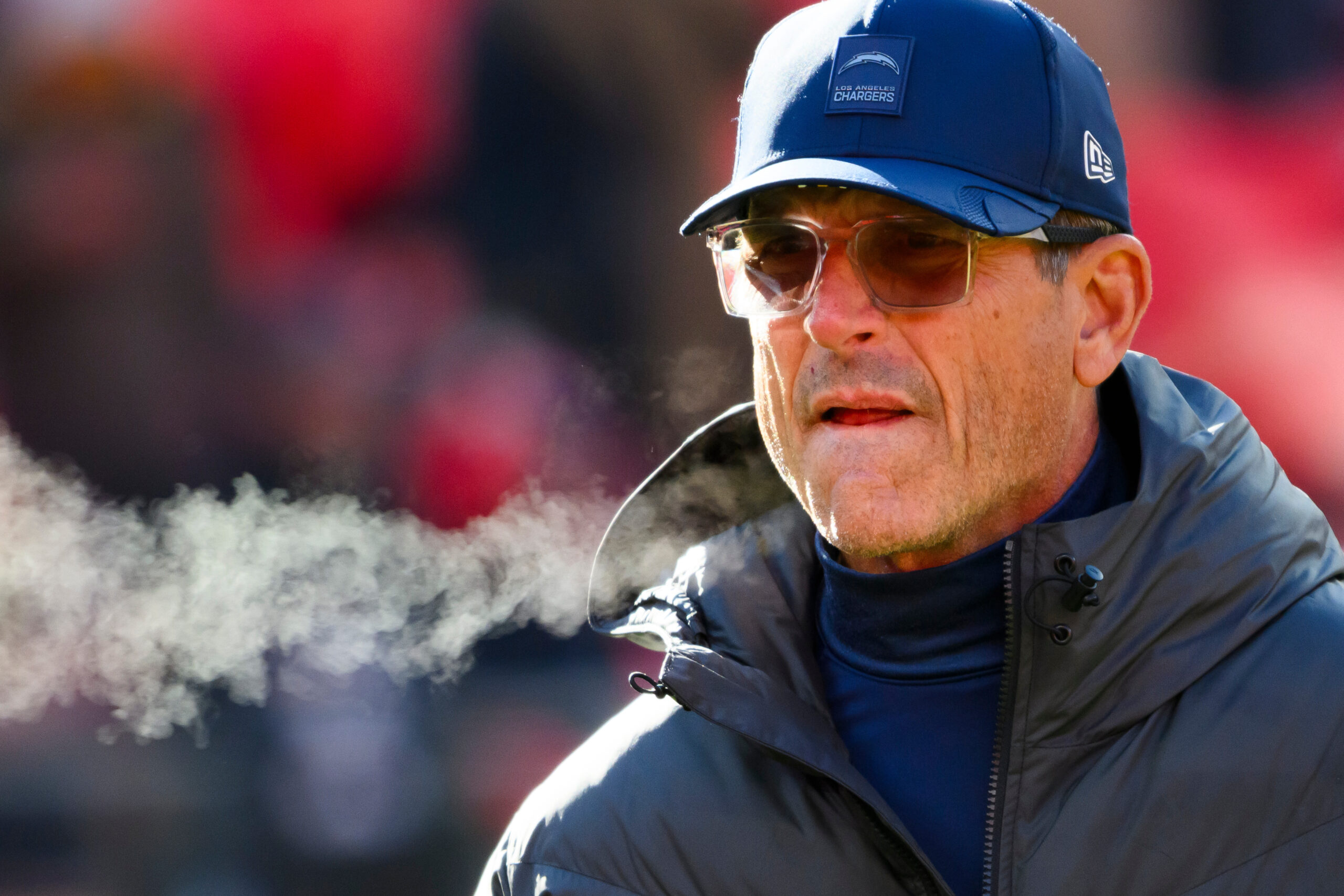 Chargers head coach Jim Harbaugh watches his team during warmups...