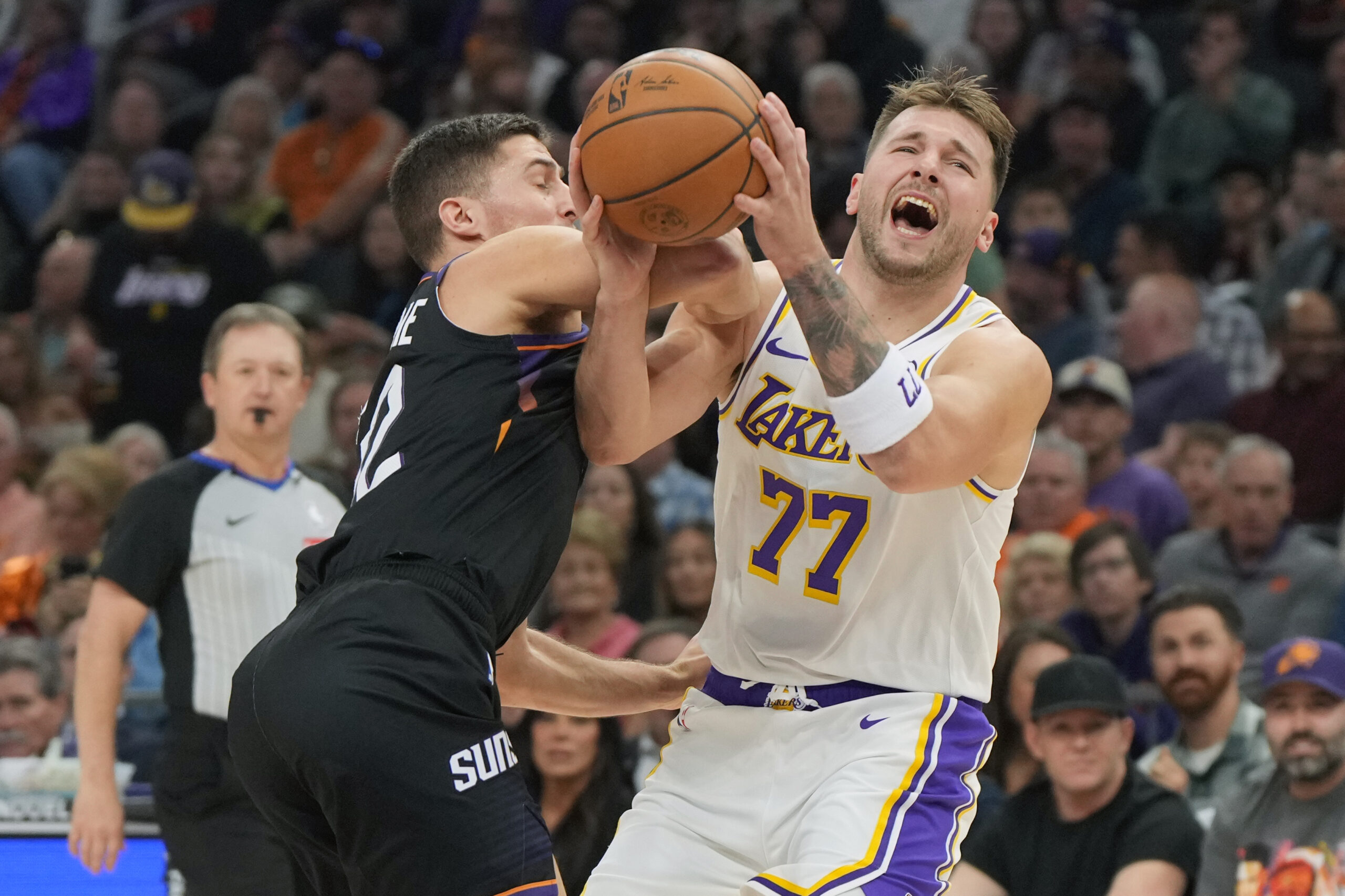 Lakers guard Luka Doncic (77) is fouled by Phoenix Suns...