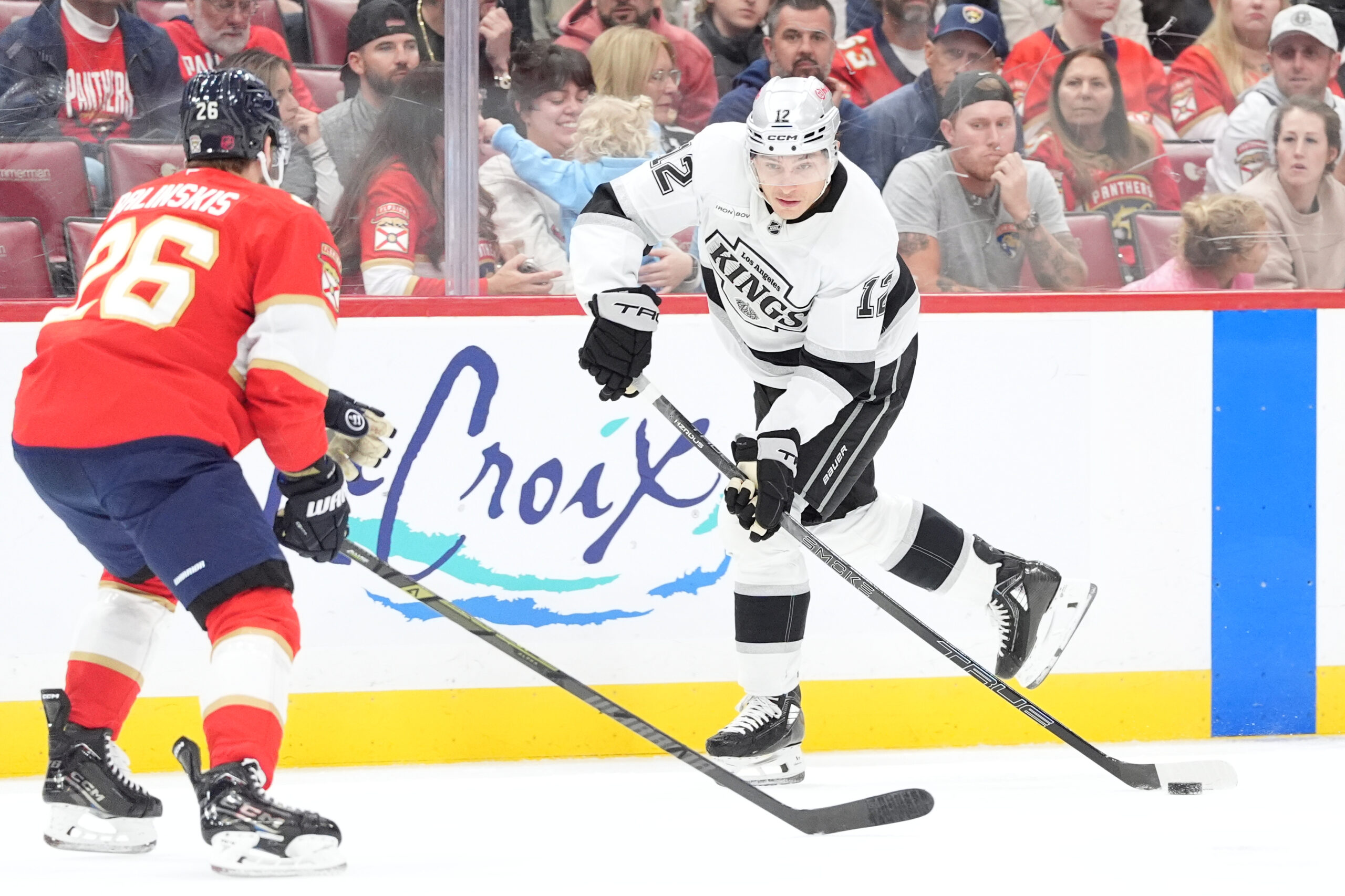 Kings left wing Trevor Moore, right, skates up the ice...