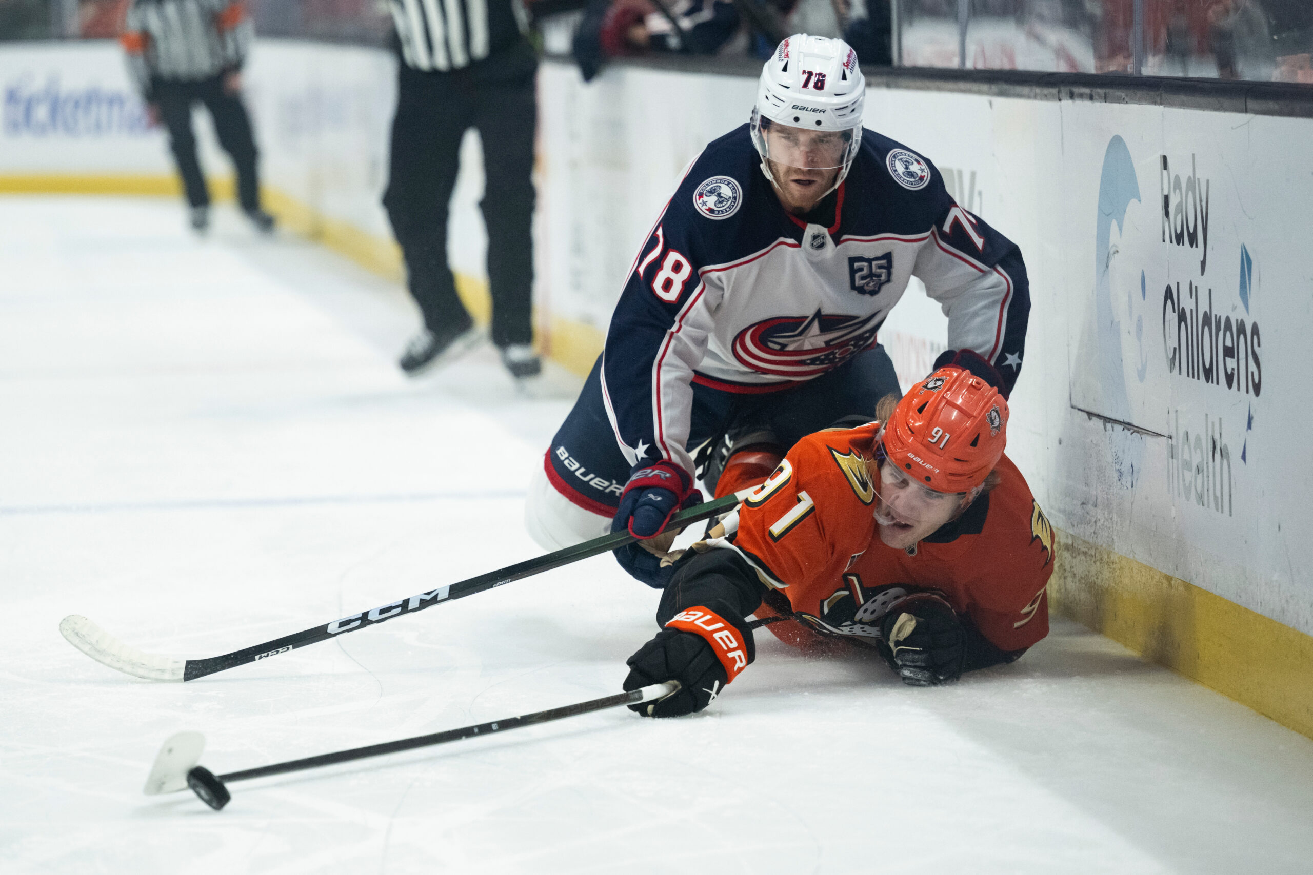 Ducks center Leo Carlsson, bottom, reaches for the puck as...