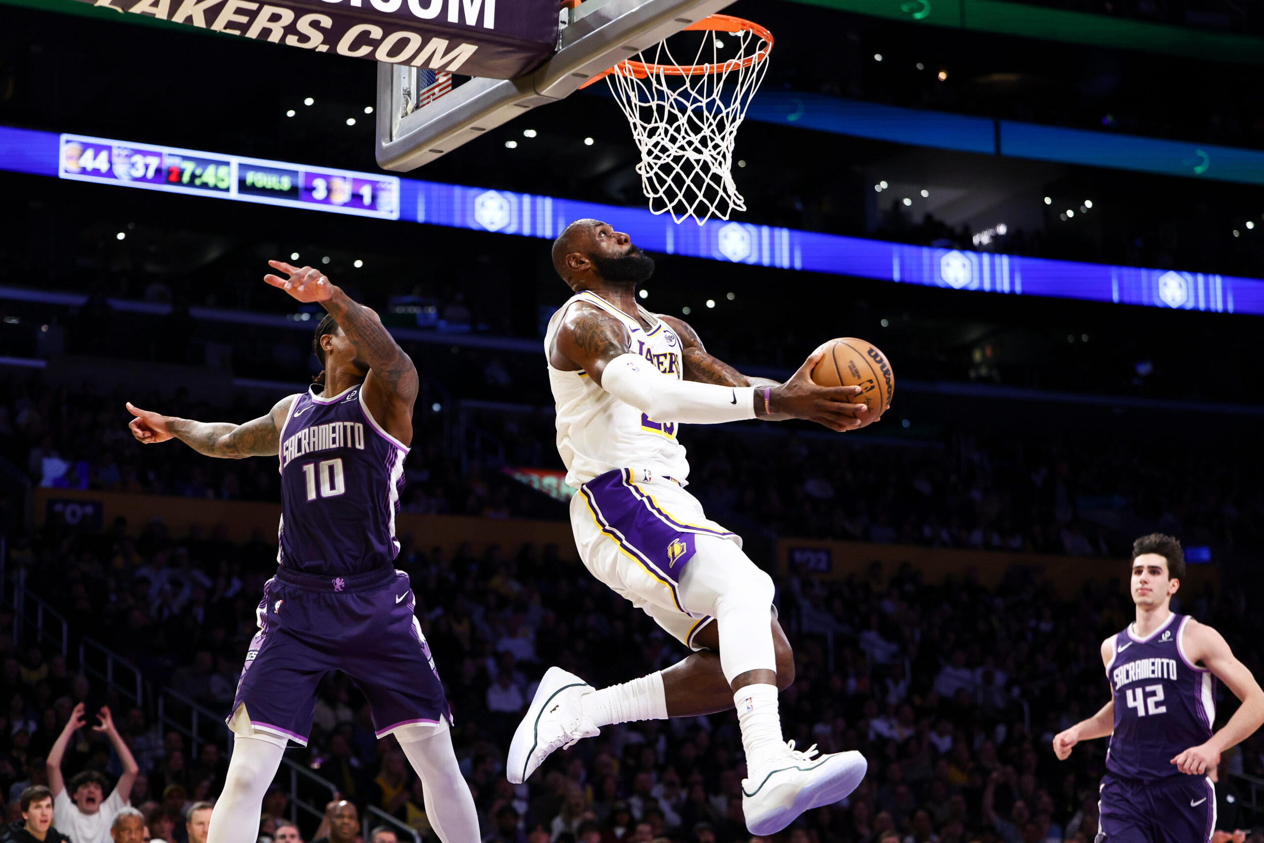 Lakers forward Lebron James, center, drives to the basket against...