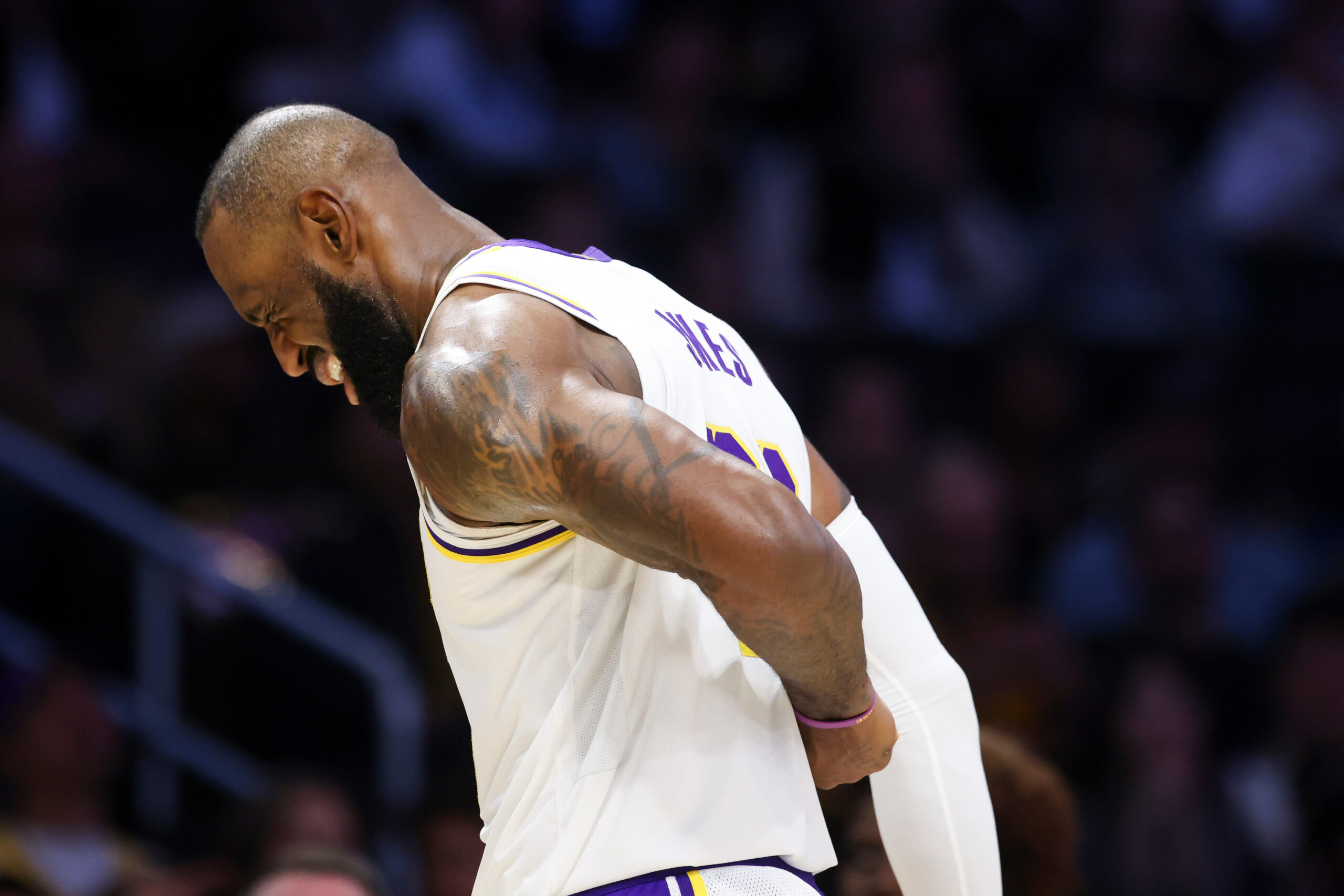 Lakers forward Lebron James reacts while holding his back during...
