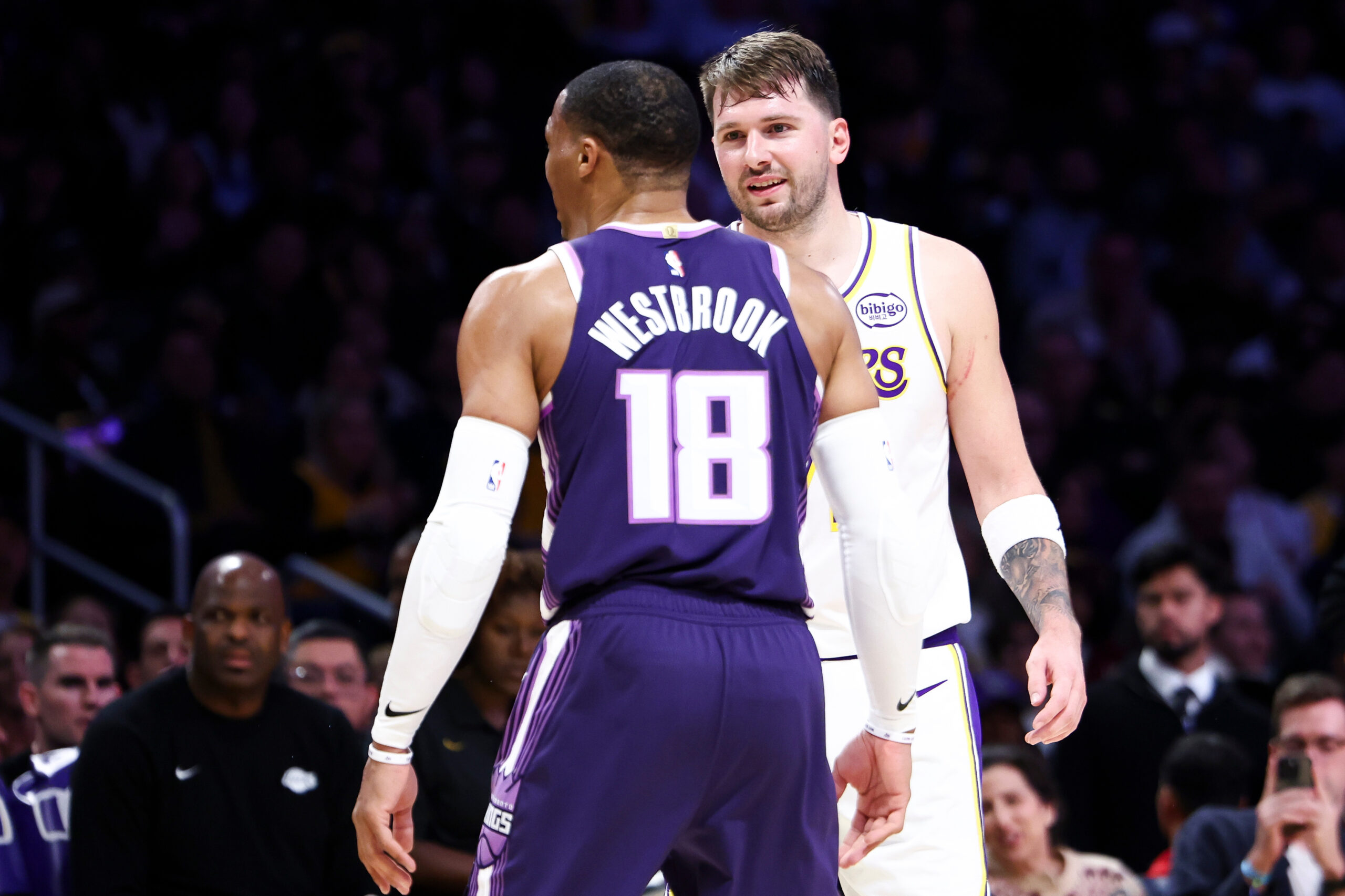 Lakers guard Luka Doncic, back, interacts with Sacramento Kings guard...