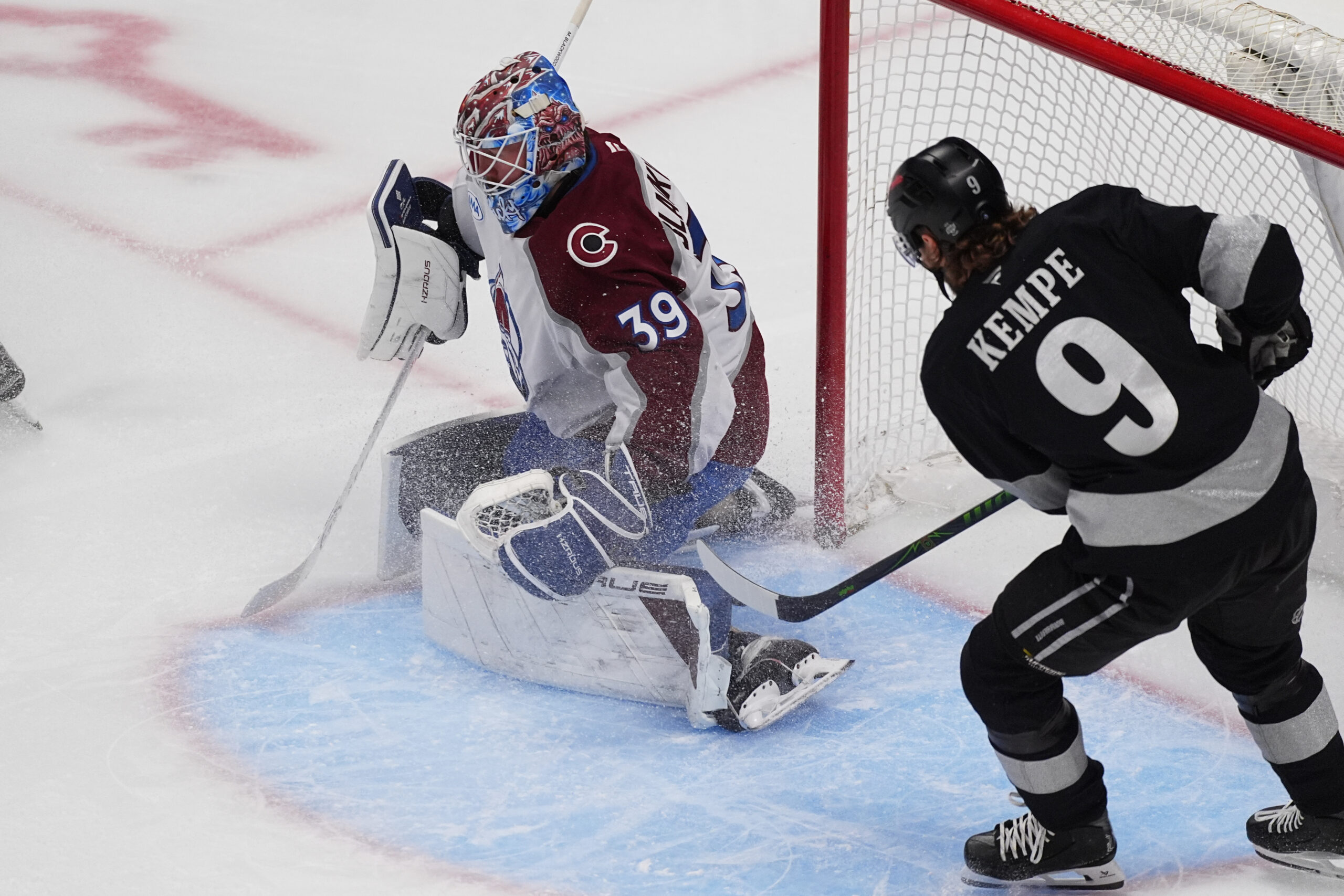 Colorado Avalanche goaltender Mackenzie Blackwood, left, stops a shot by...