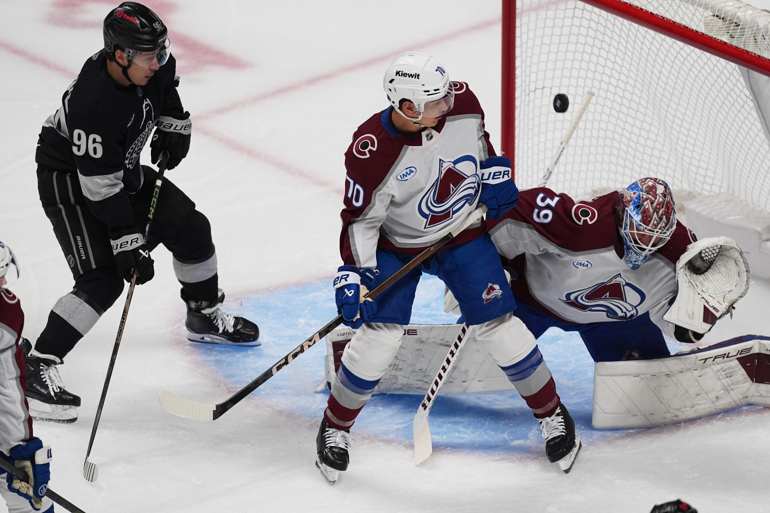 Colorado Avalanche goaltender Mackenzie Blackwood, right, avoids the puck as...