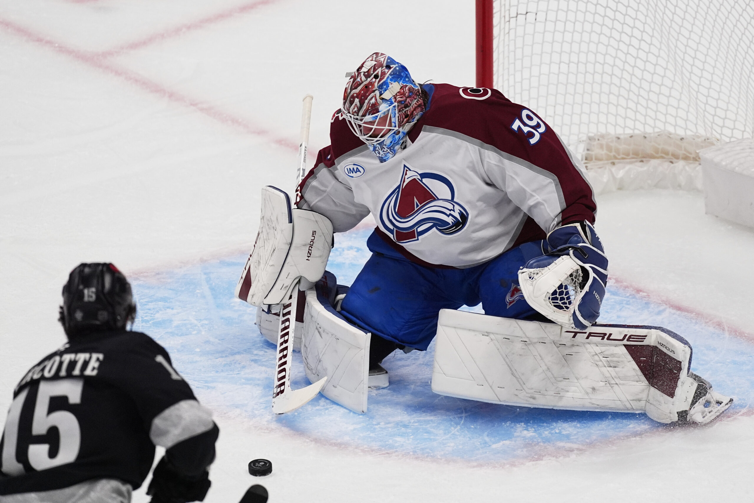 Colorado Avalanche goaltender Mackenzie Blackwood, right, makes a stick save...