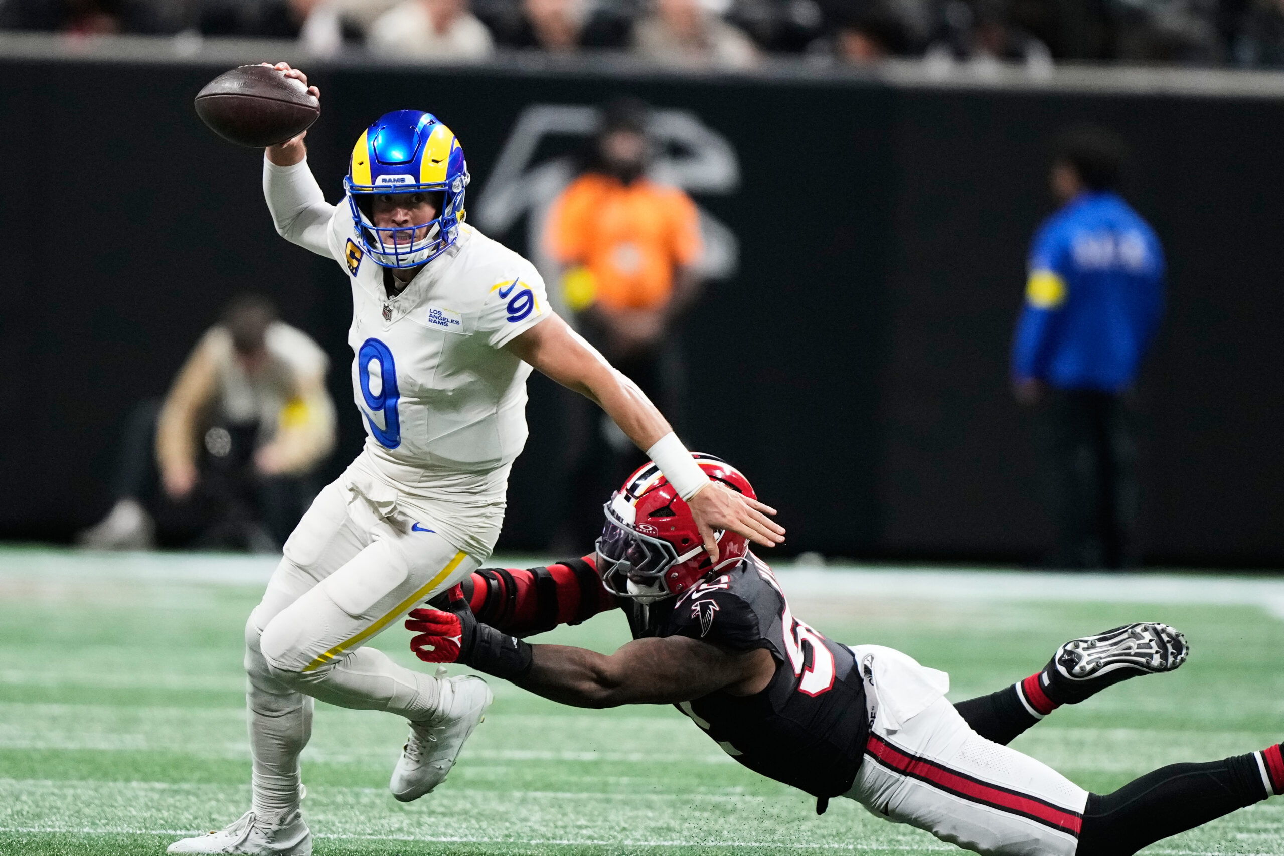 Rams quarterback Matthew Stafford tries to scramble away from Atlanta...