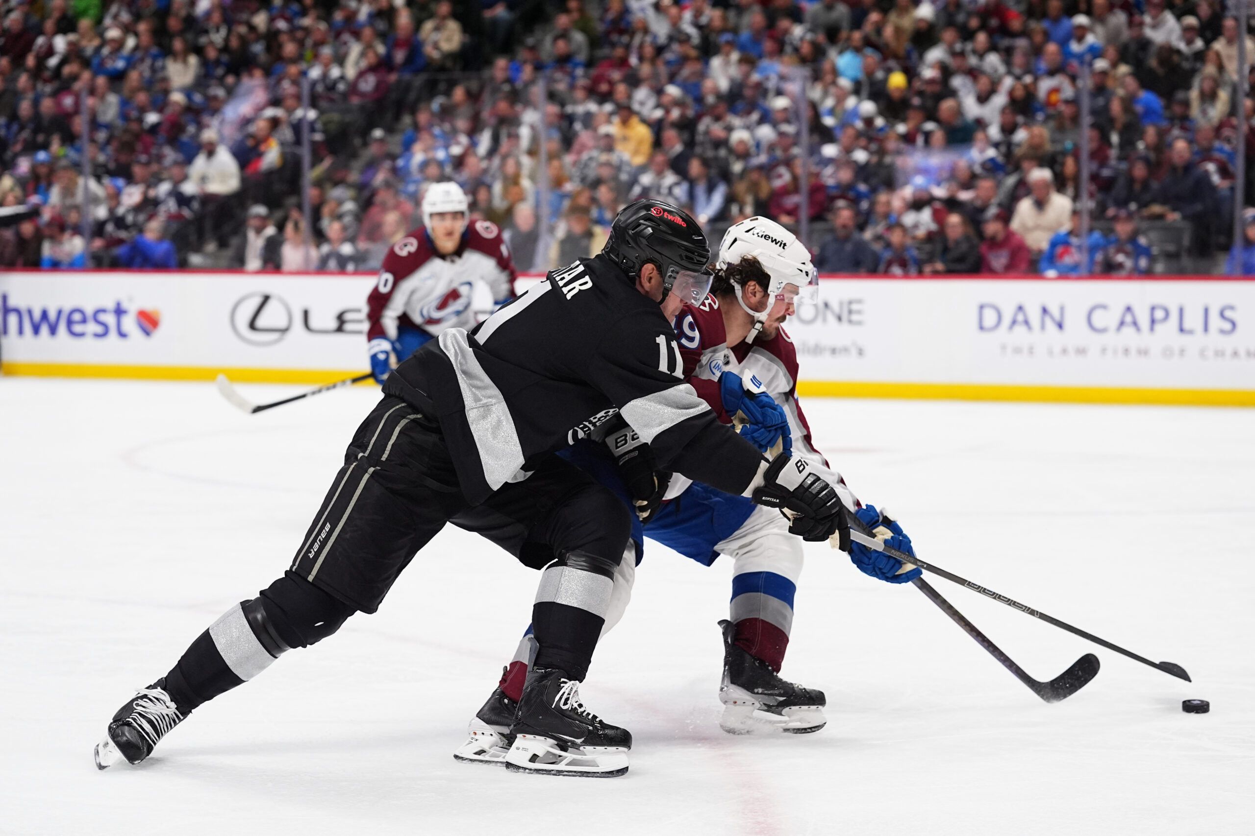 Kings center Anze Kopitar, left, pursues the puck with Colorado...