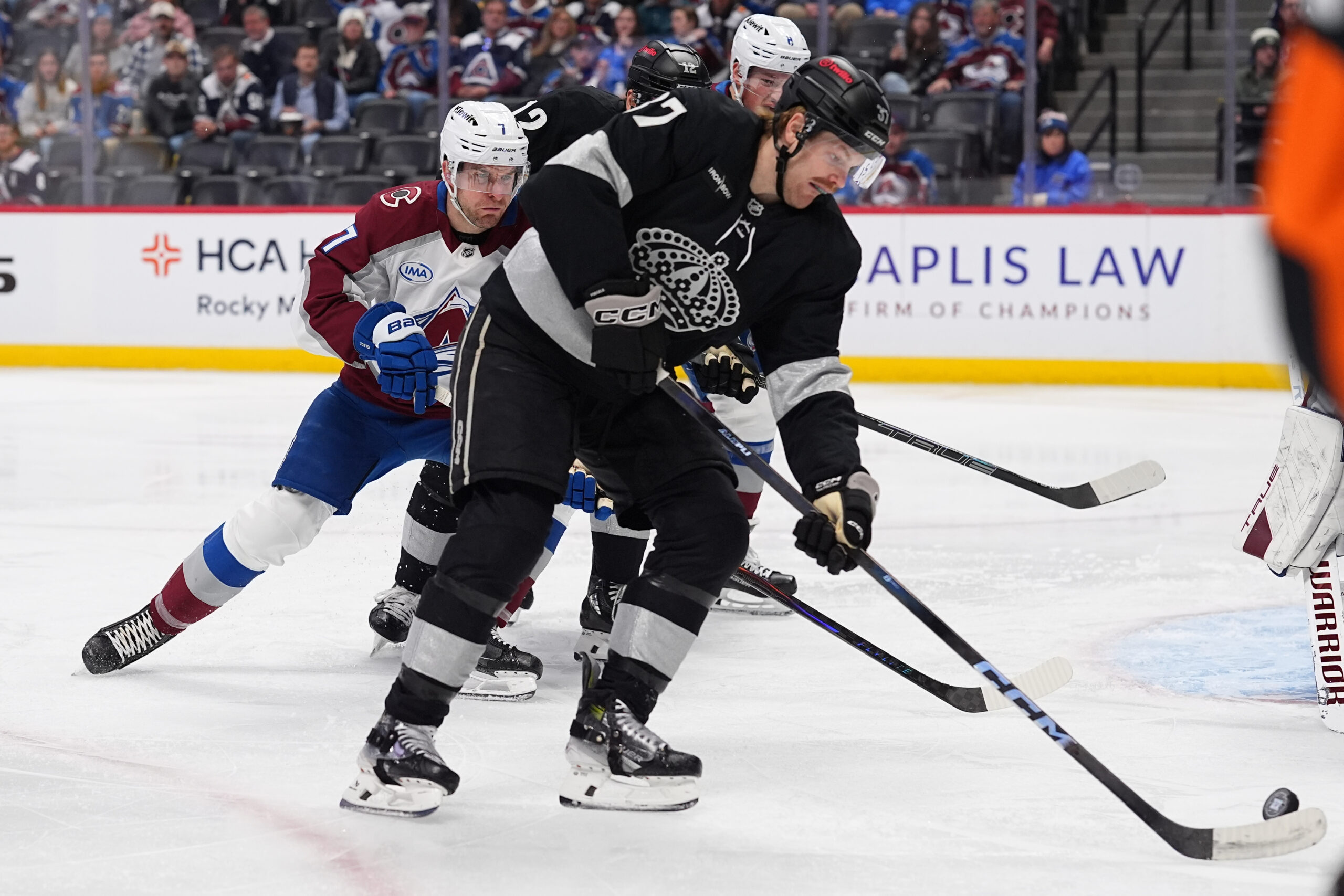 Kings left wing Warren Foegele, front, collects the puck as...