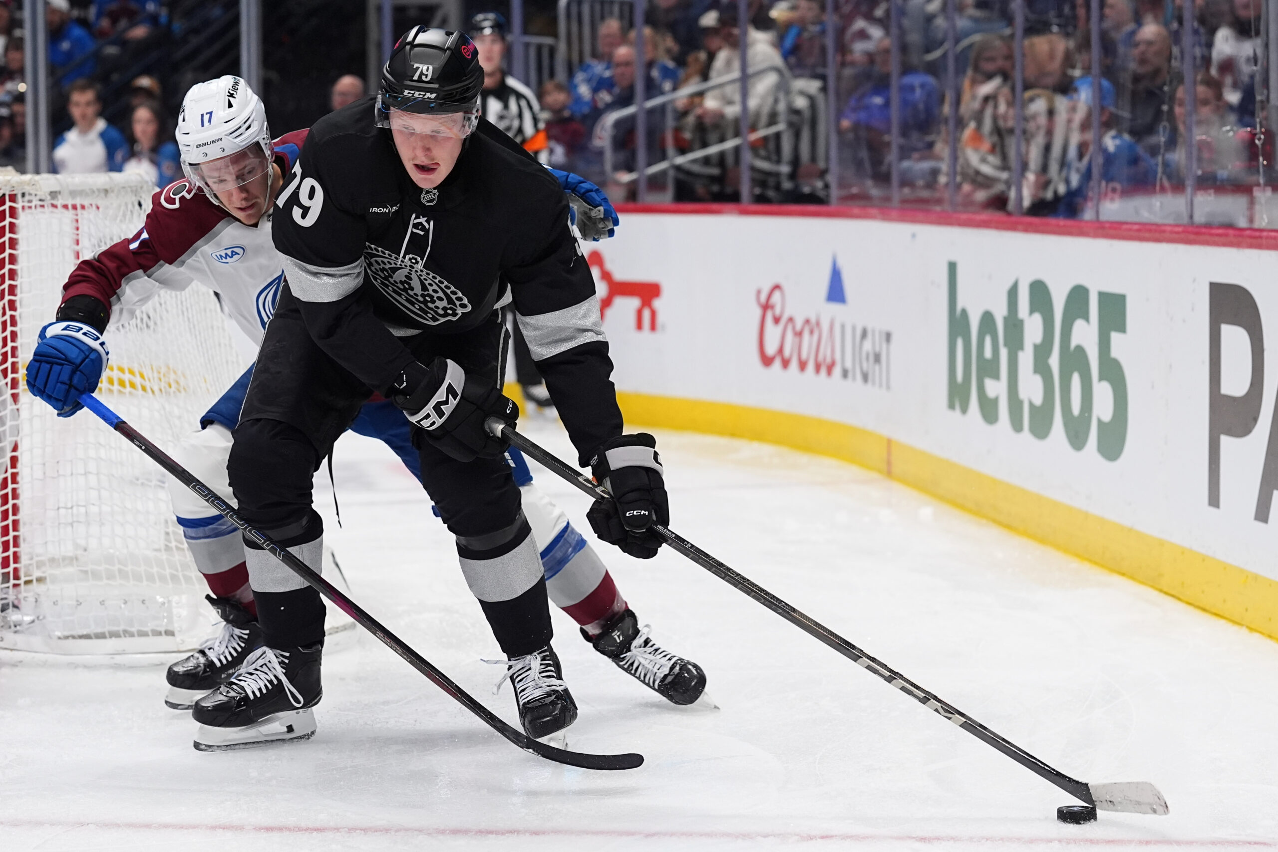 Kings center Samuel Helenius, front, collects the puck as Colorado...