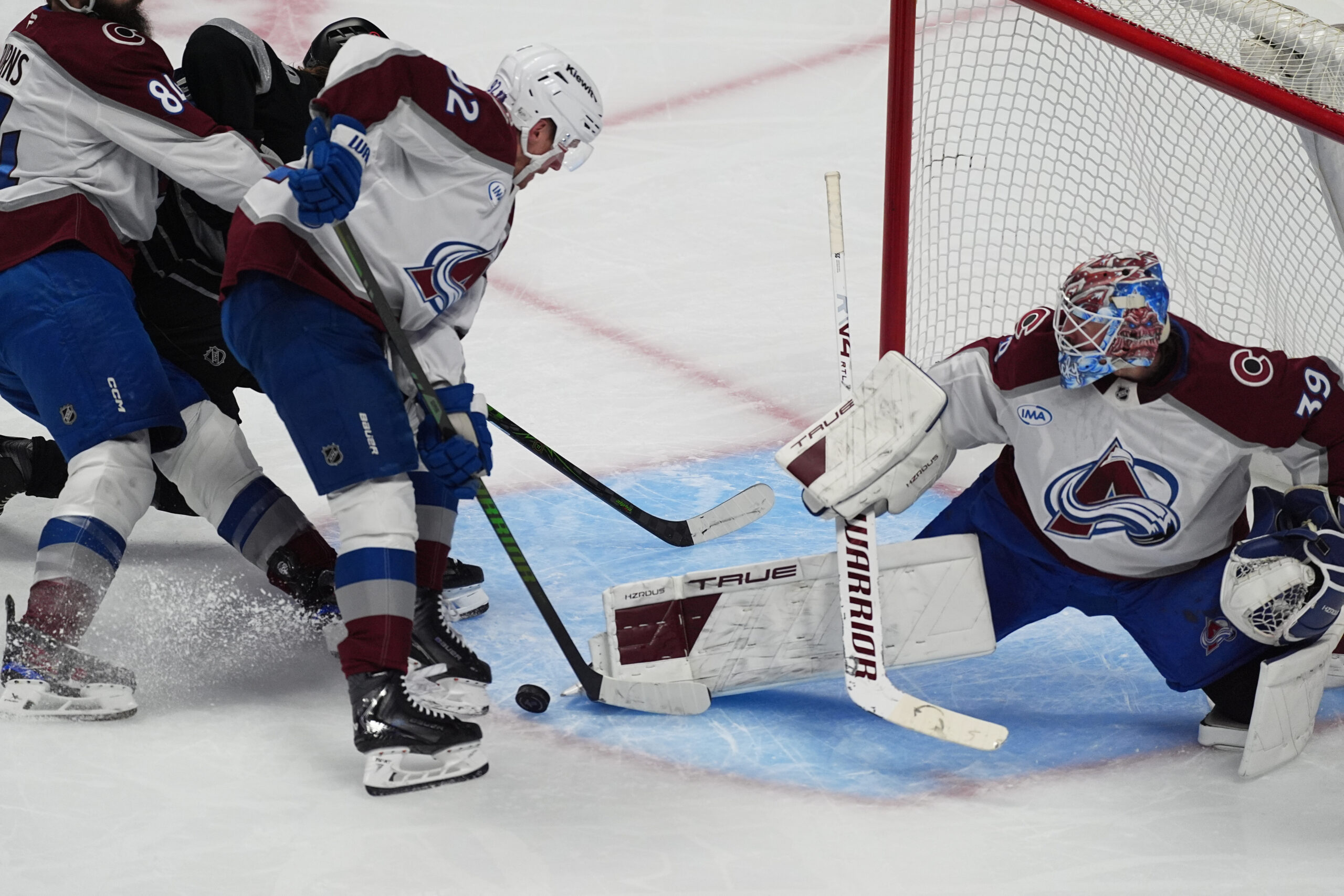 Colorado Avalanche goaltender Mackenzie Blackwood, right, makes a kick save...