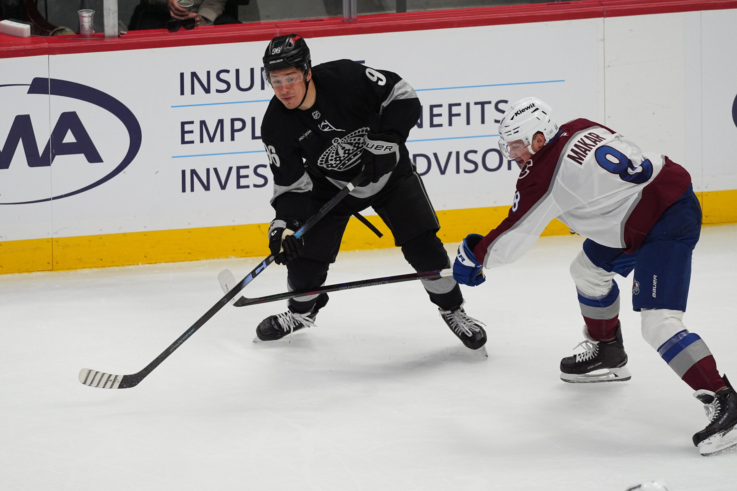 Kings left wing Andrei Kuzmenko, left, passes the puck as...