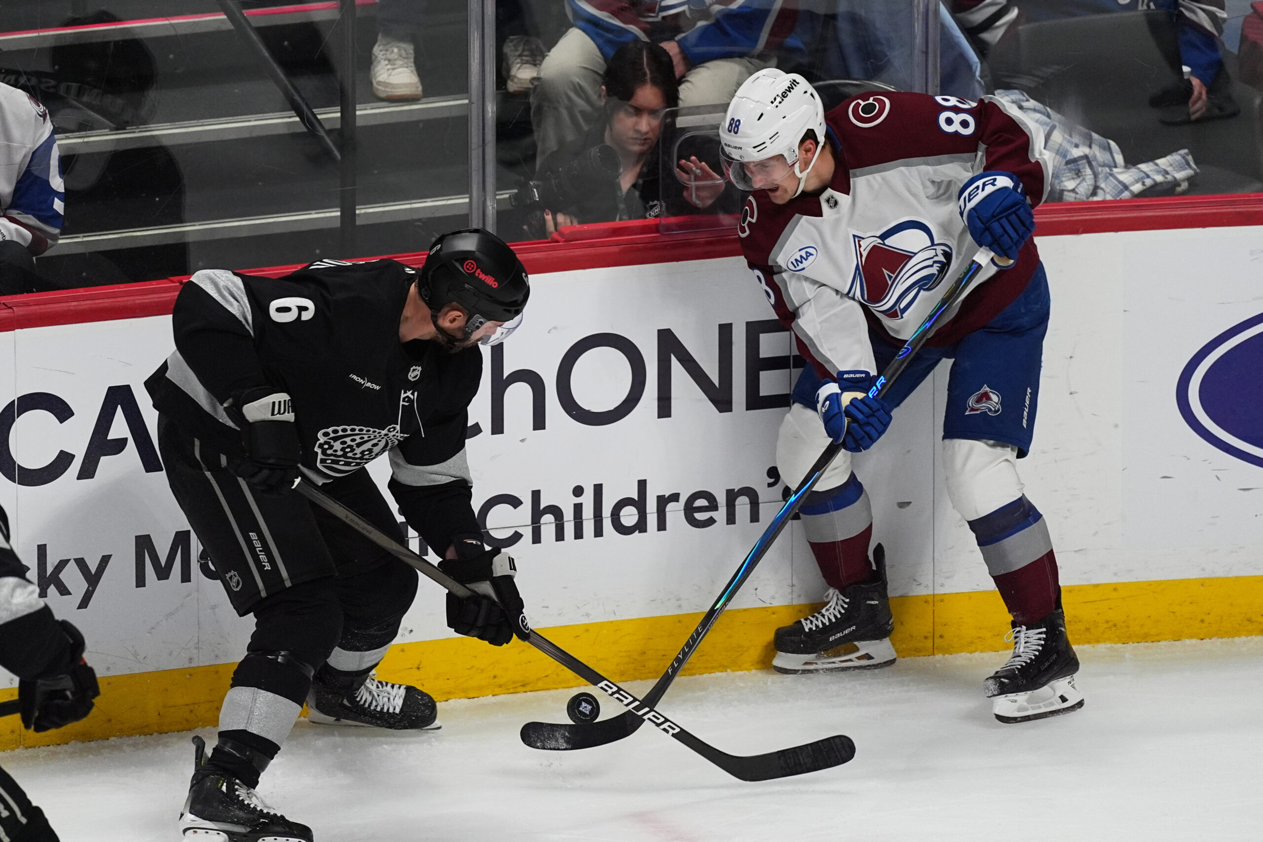 Kings defenseman Joel Edmundson, left, fights for control of the...