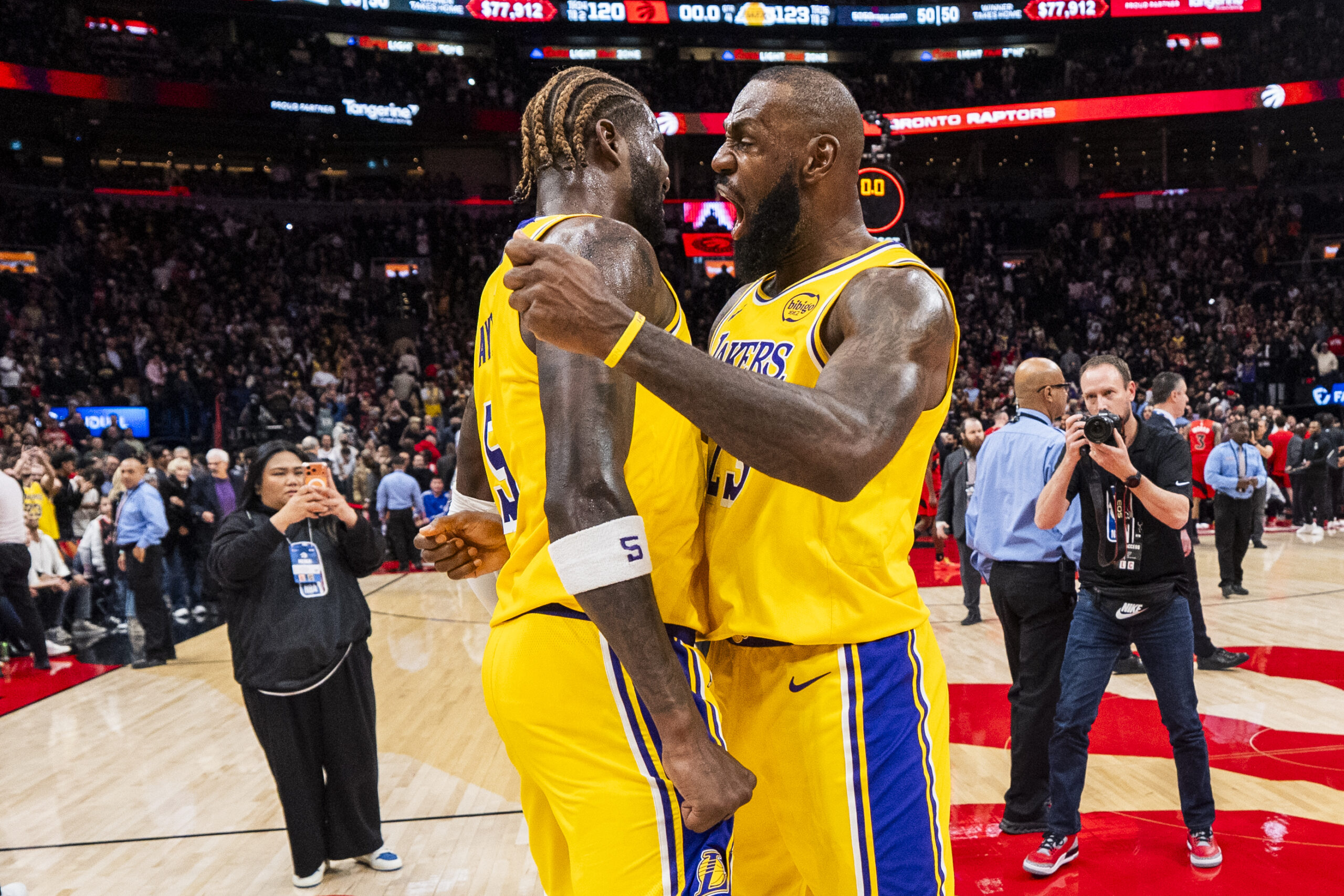 Lakers star LeBron James, right, celebrates with teammate Deandre Ayton...