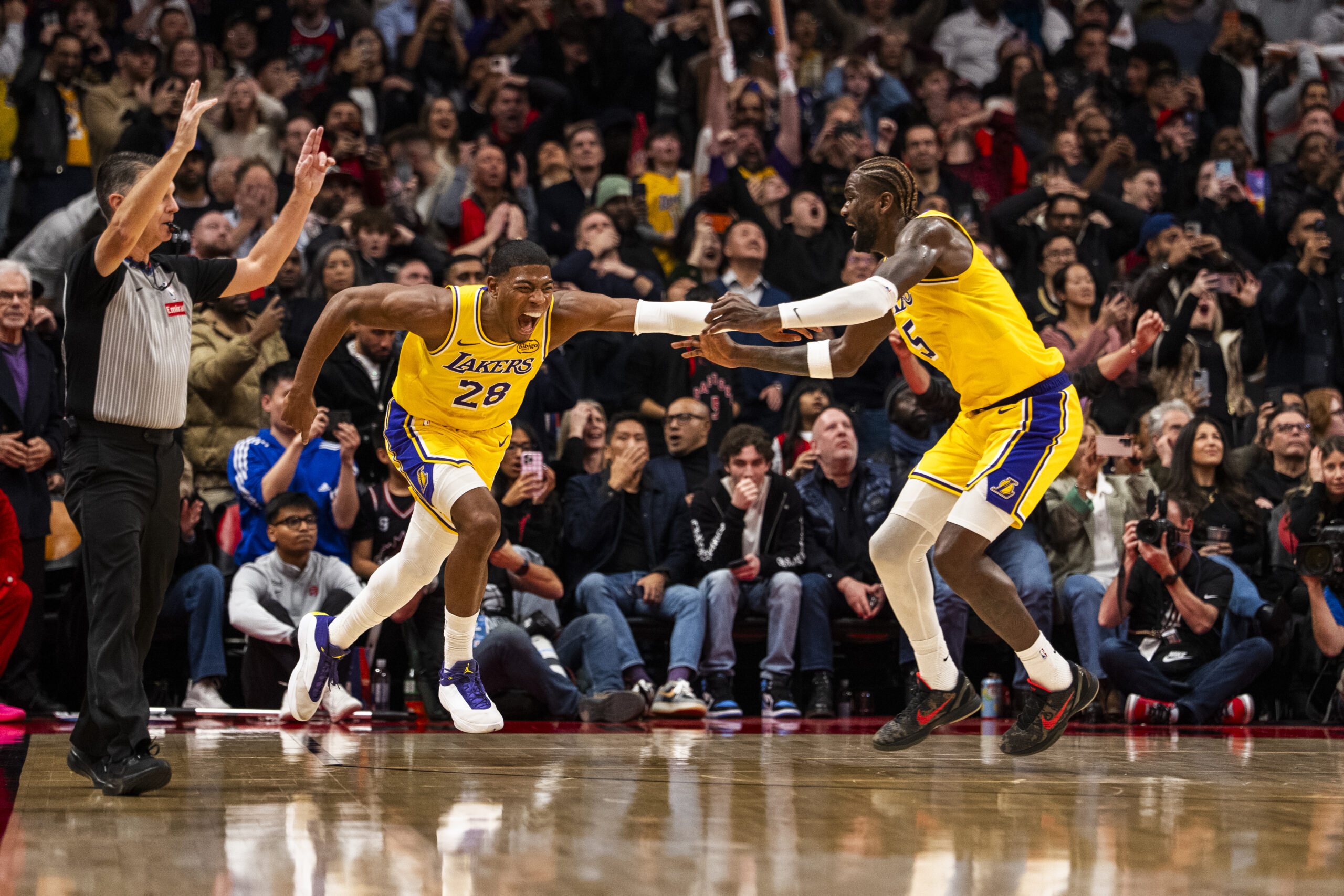 Lakers forward Rui Hachimura, left, celebrates with center Deandre Ayton...