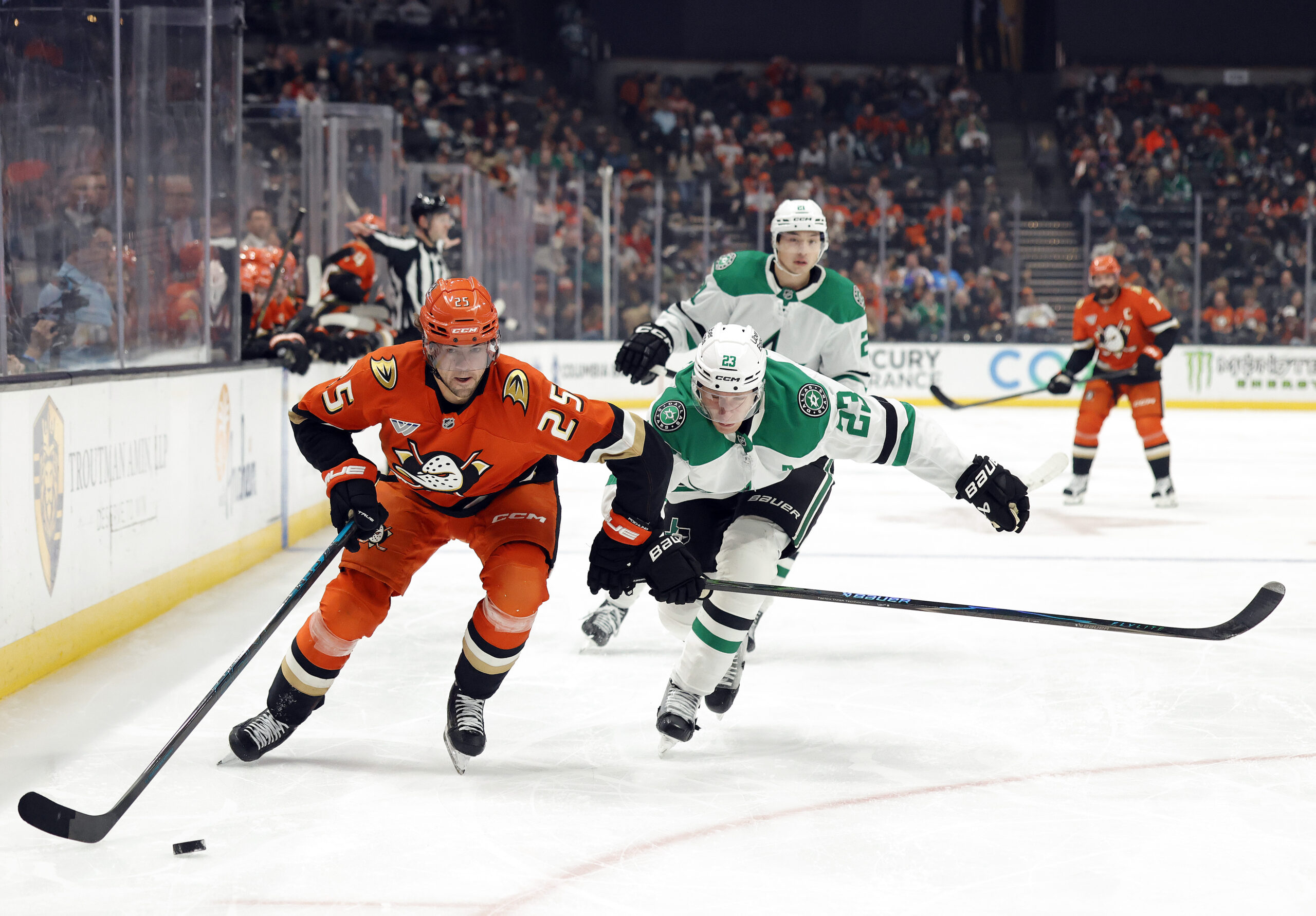 The Ducks’ Ryan Poehling, left, skates with the puck as...