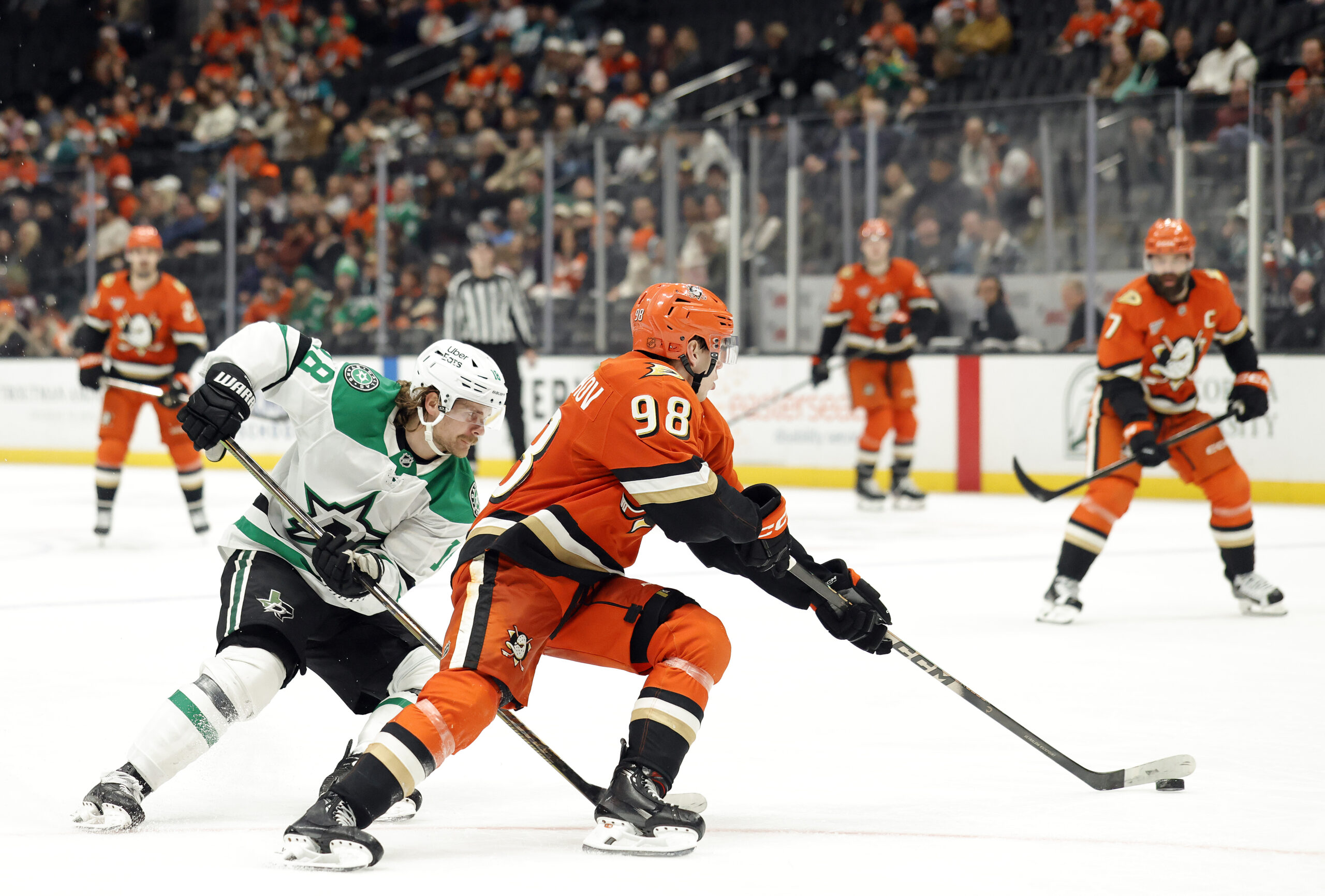 The Ducks’ Pavel Mintyukov, right, skates with the puck as...