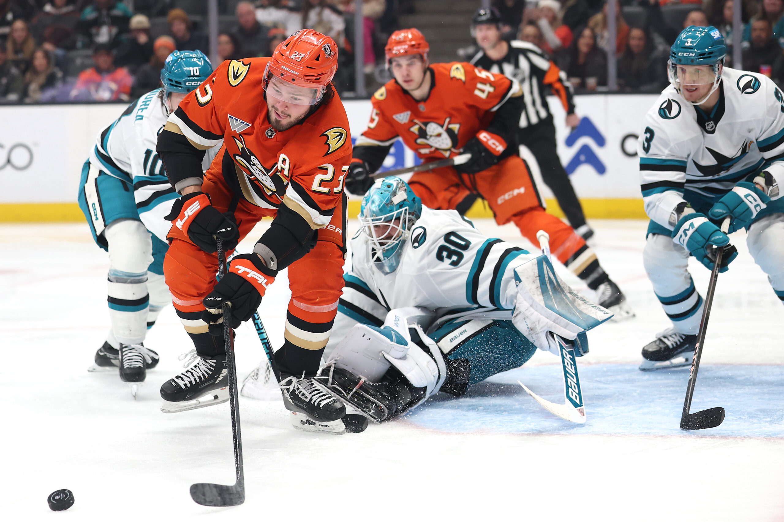 The Ducks’ Mason McTavish, left, chases a loose puck after...