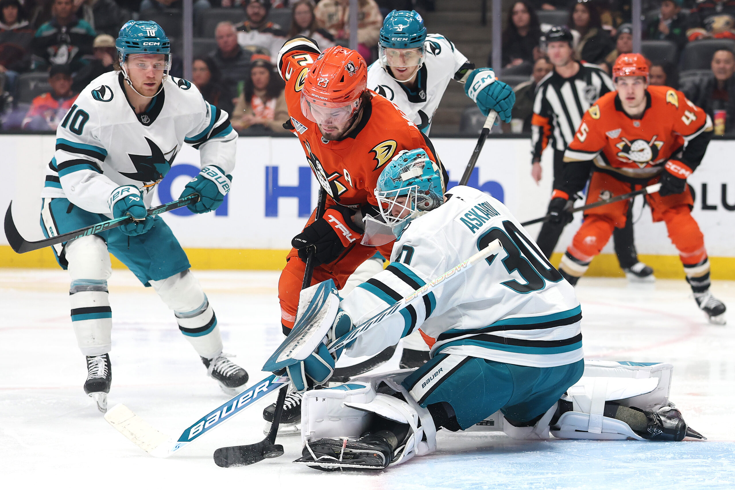 The Ducks’ Mason McTavish (23) tries to control the puck...