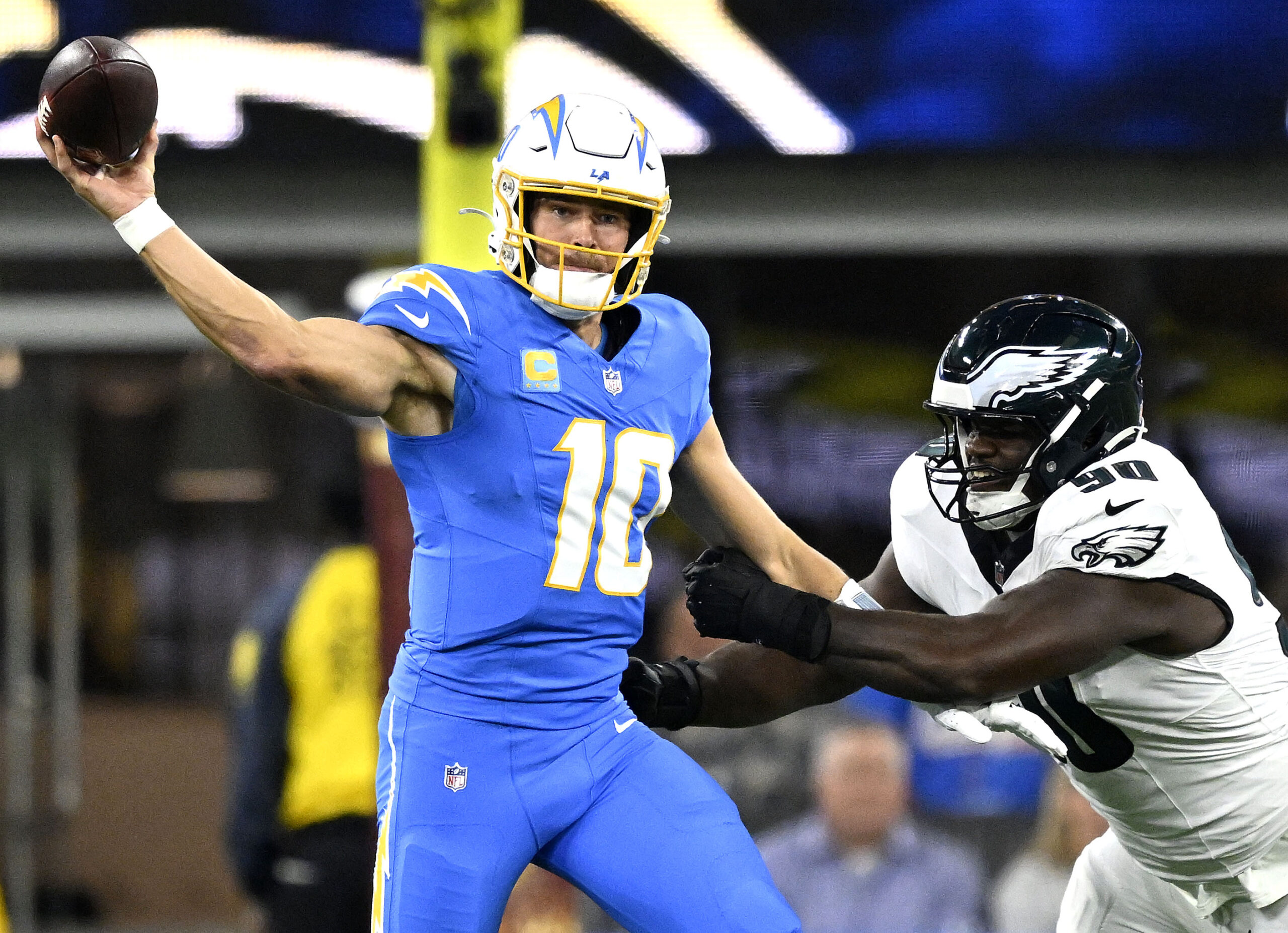 Chargers quarterback Justin Herbert gets a pass off as he...