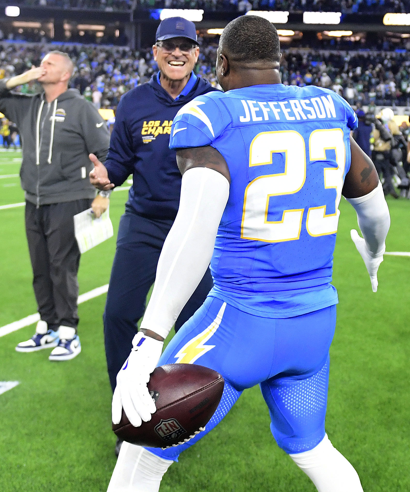 Chargers safety Tony Jefferson celebrates with head coach Jim Harbaugh...