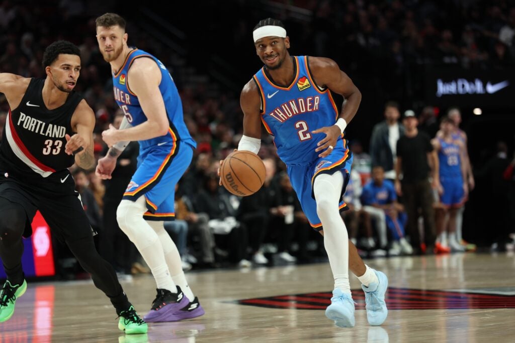 Nov 5, 2025; Portland, Oregon, USA; Oklahoma City Thunder guard Shai Gilgeous-Alexander (2) dribbles the ball past Portland Trail Blazers forward Toumani Camara (33) as teammate Thunder’s center/forward Isaiah Hartenstein (55) watches during the first half at Moda Center. Mandatory Credit: Jaime Valdez-Imagn Images