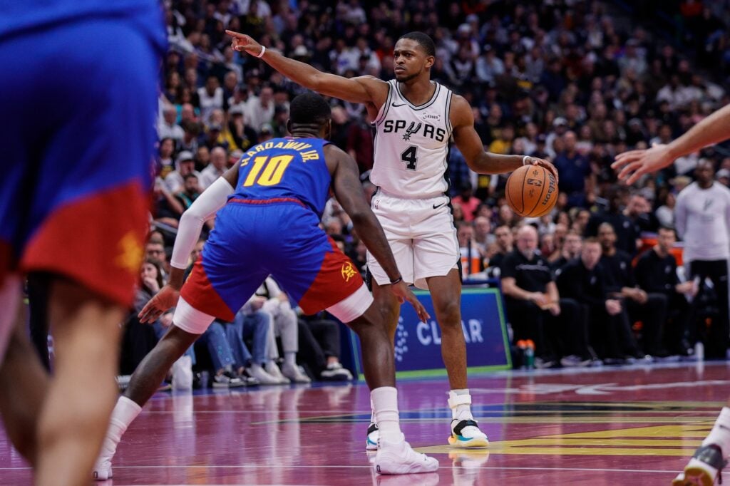 San Antonio Spurs guard De'Aaron Fox (4) gestures as Denver Nuggets guard Tim Hardaway Jr. (10) guards in the fourth quarter at Ball Arena.