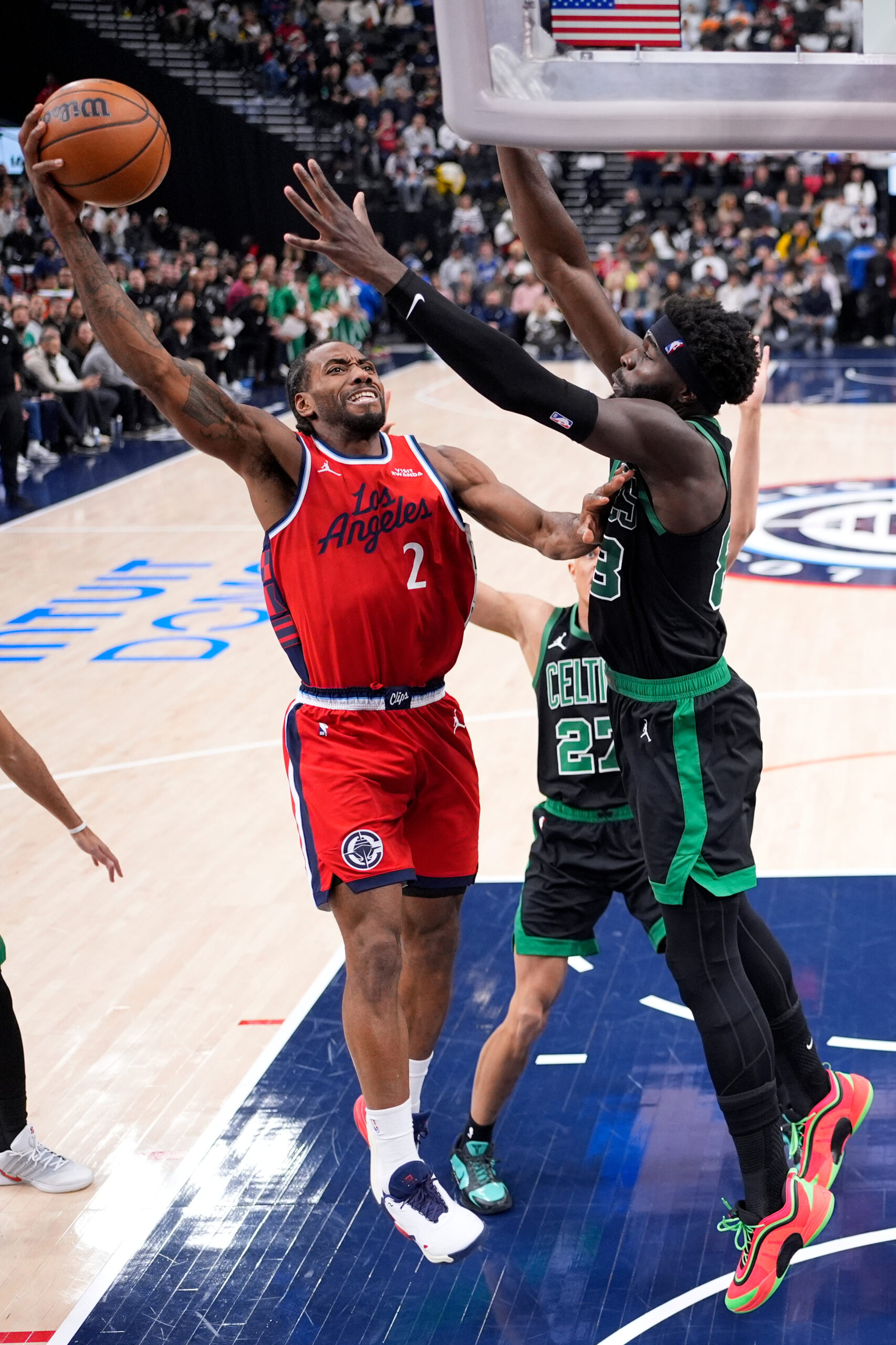 Clippers forward Kawhi Leonard, left, shoots as Boston Celtics center...