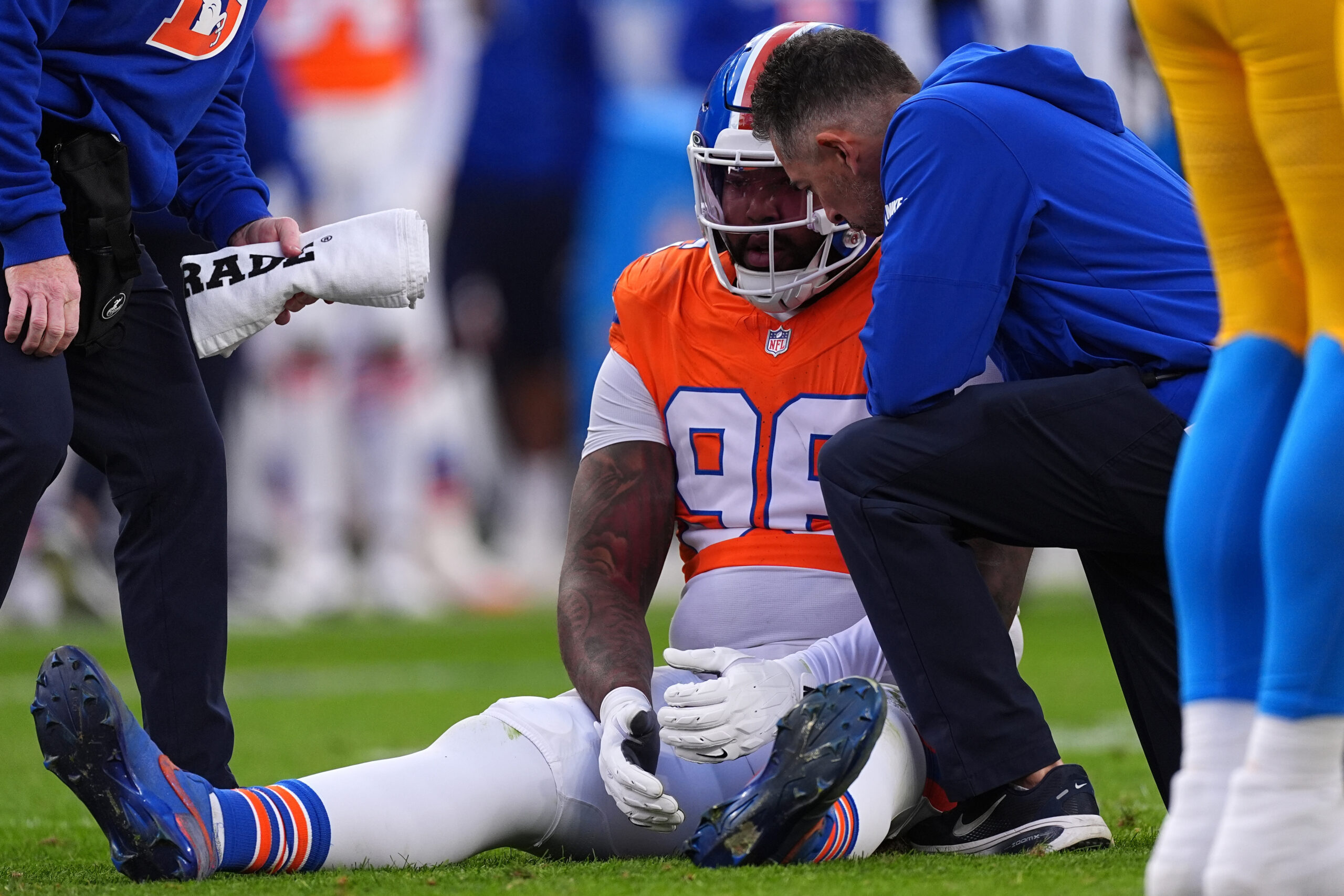 Trainers attend to Denver Broncos defensive end John Franklin-Myers (98)...