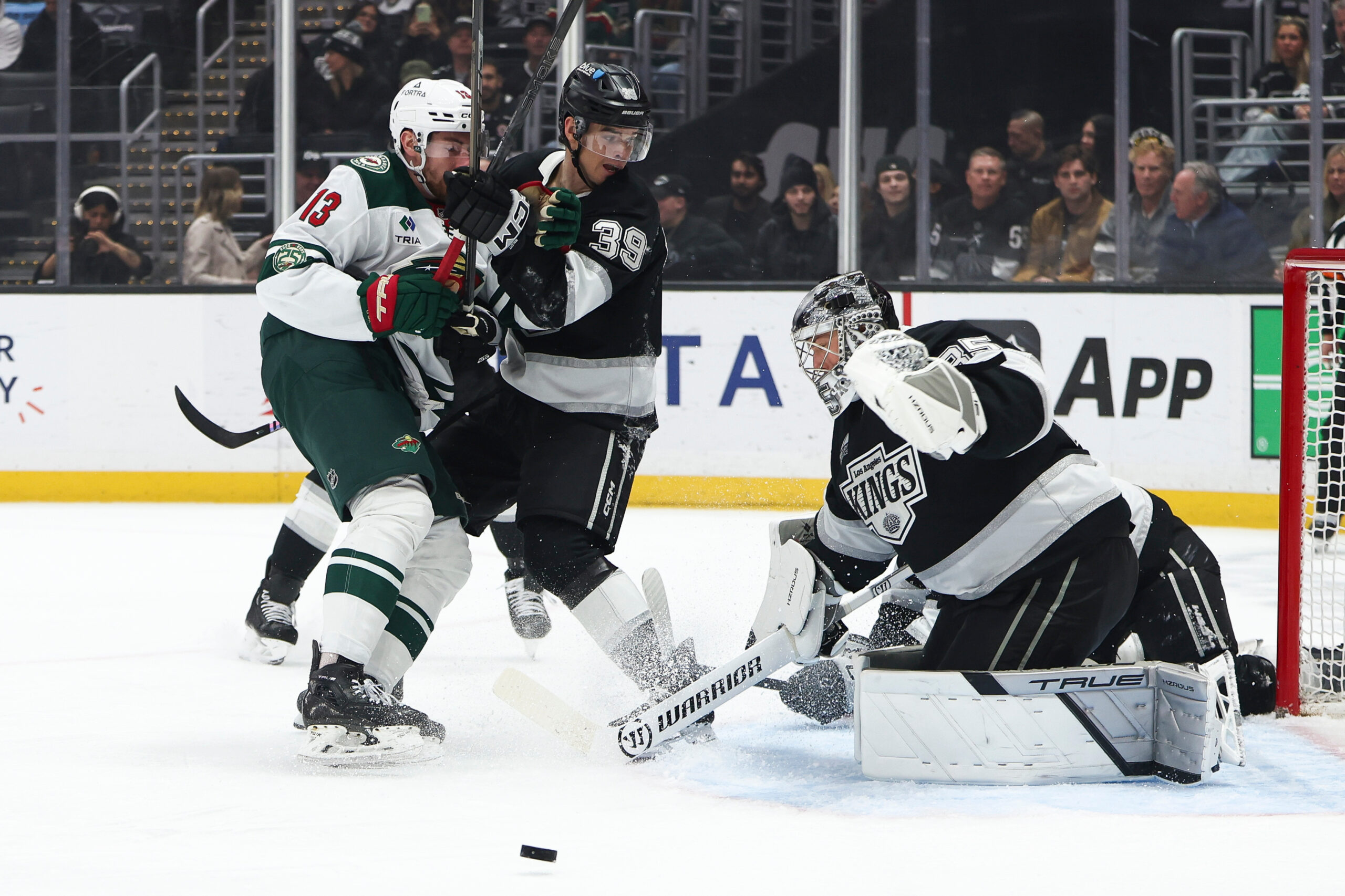Kings goaltender Darcy Kuemper, right, makes a save as Minnesota...