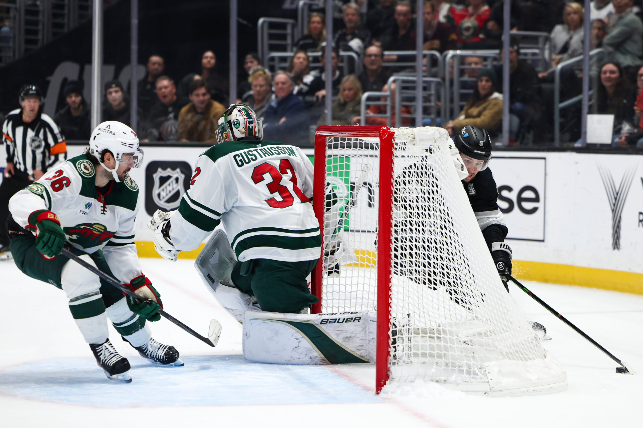 Kings right wing Adrian Kempe, right, skates around the goal...
