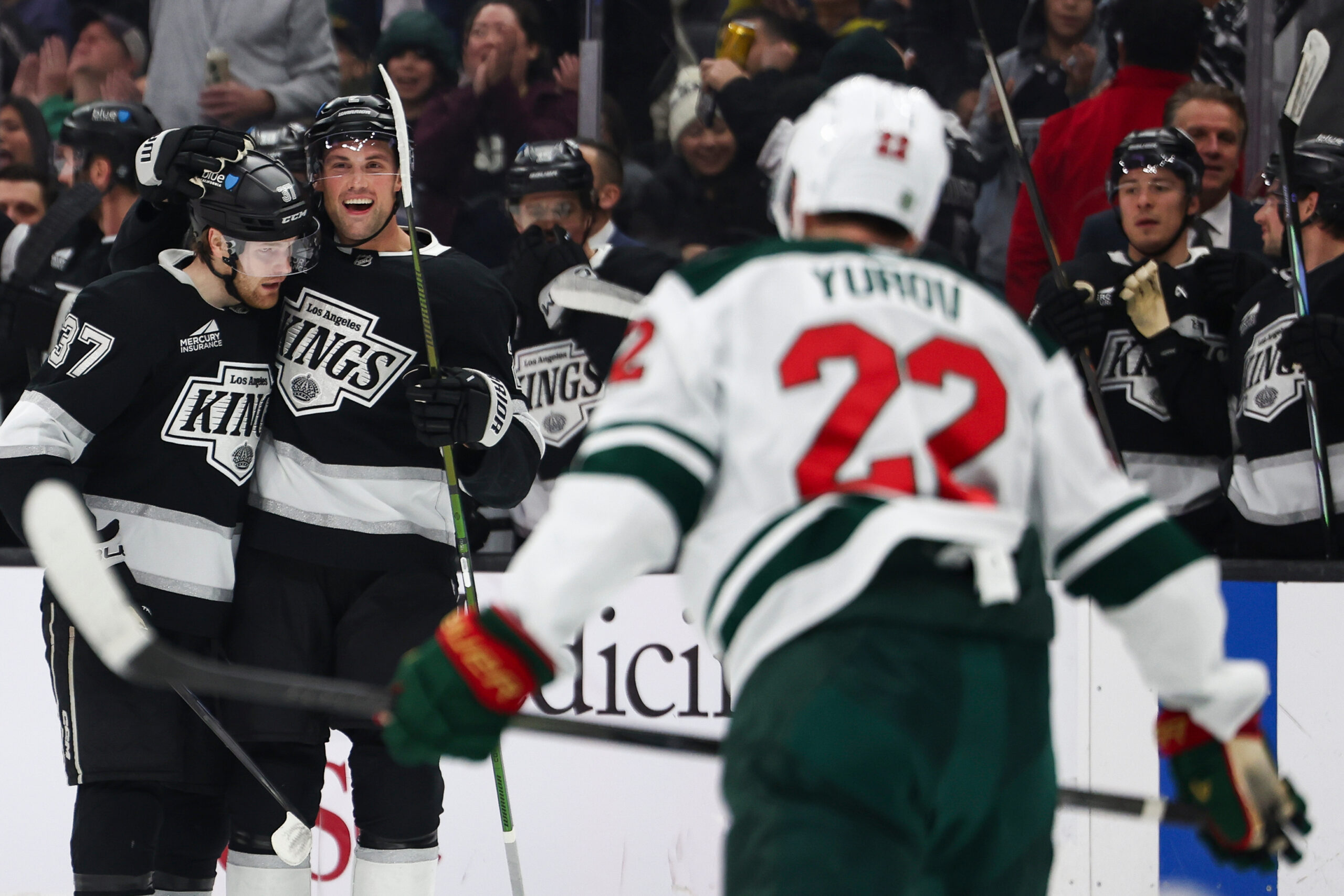 Kings left wing Warren Foegele (37) and defenseman Brian Dumoulin,...