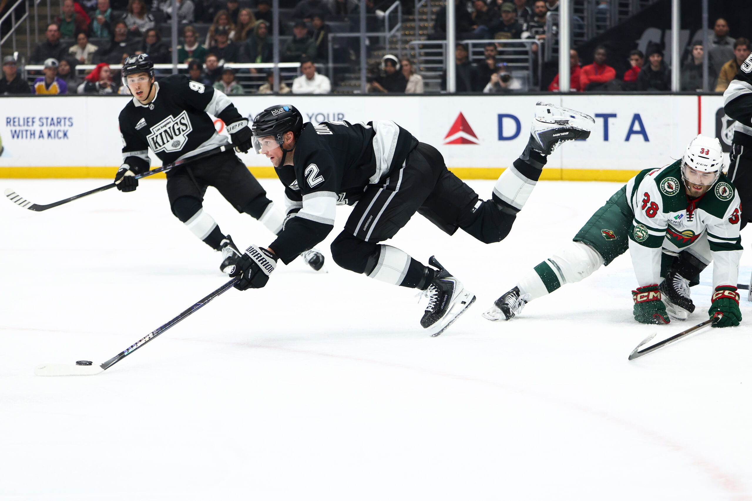 Kings defenseman Brian Dumoulin (2) trips over Minnesota Wild right...